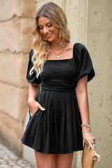 Women's romper with a square neckline, pleated detailing, and pockets.