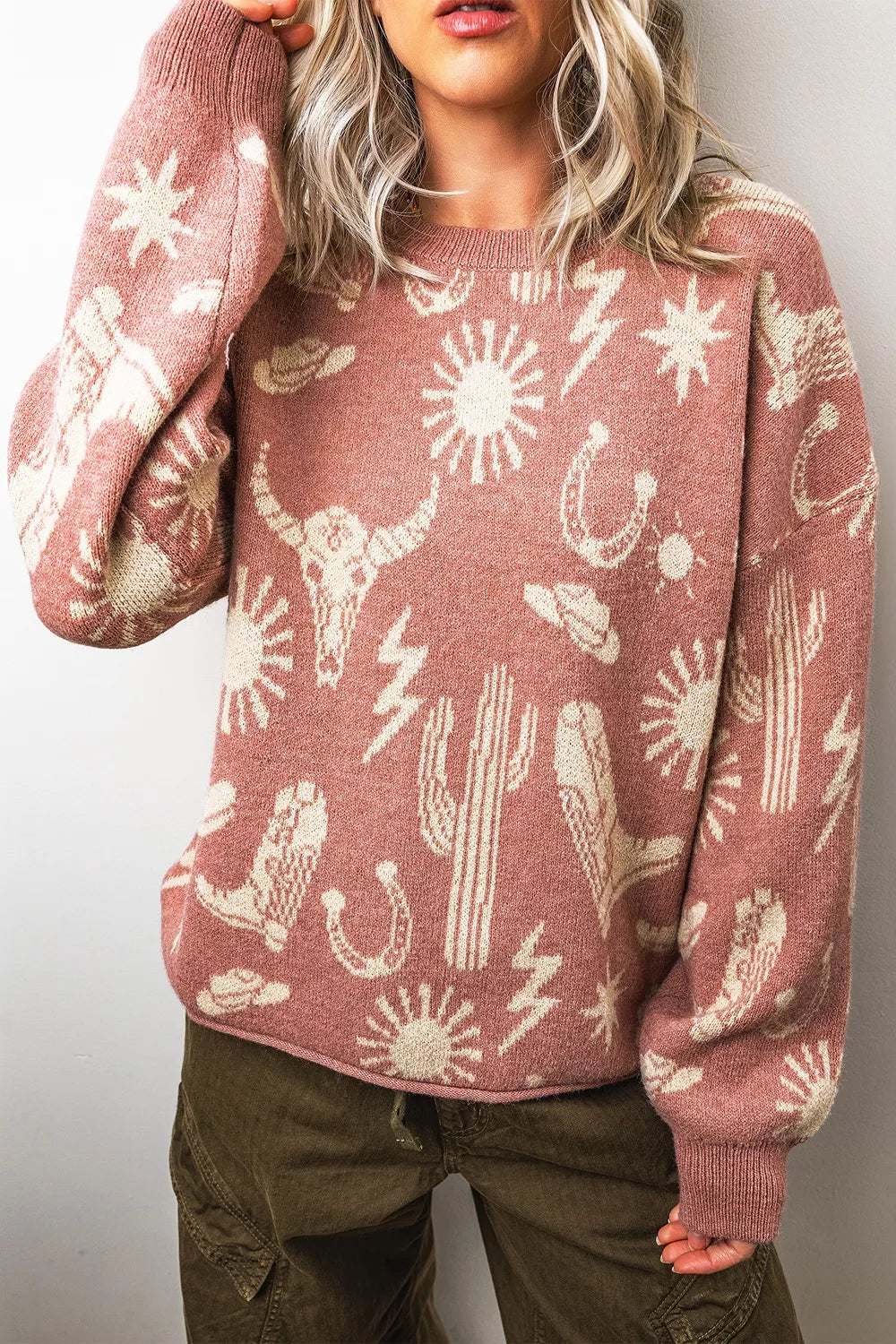 On-model front view of the dusty rose western sweater with one arm raised