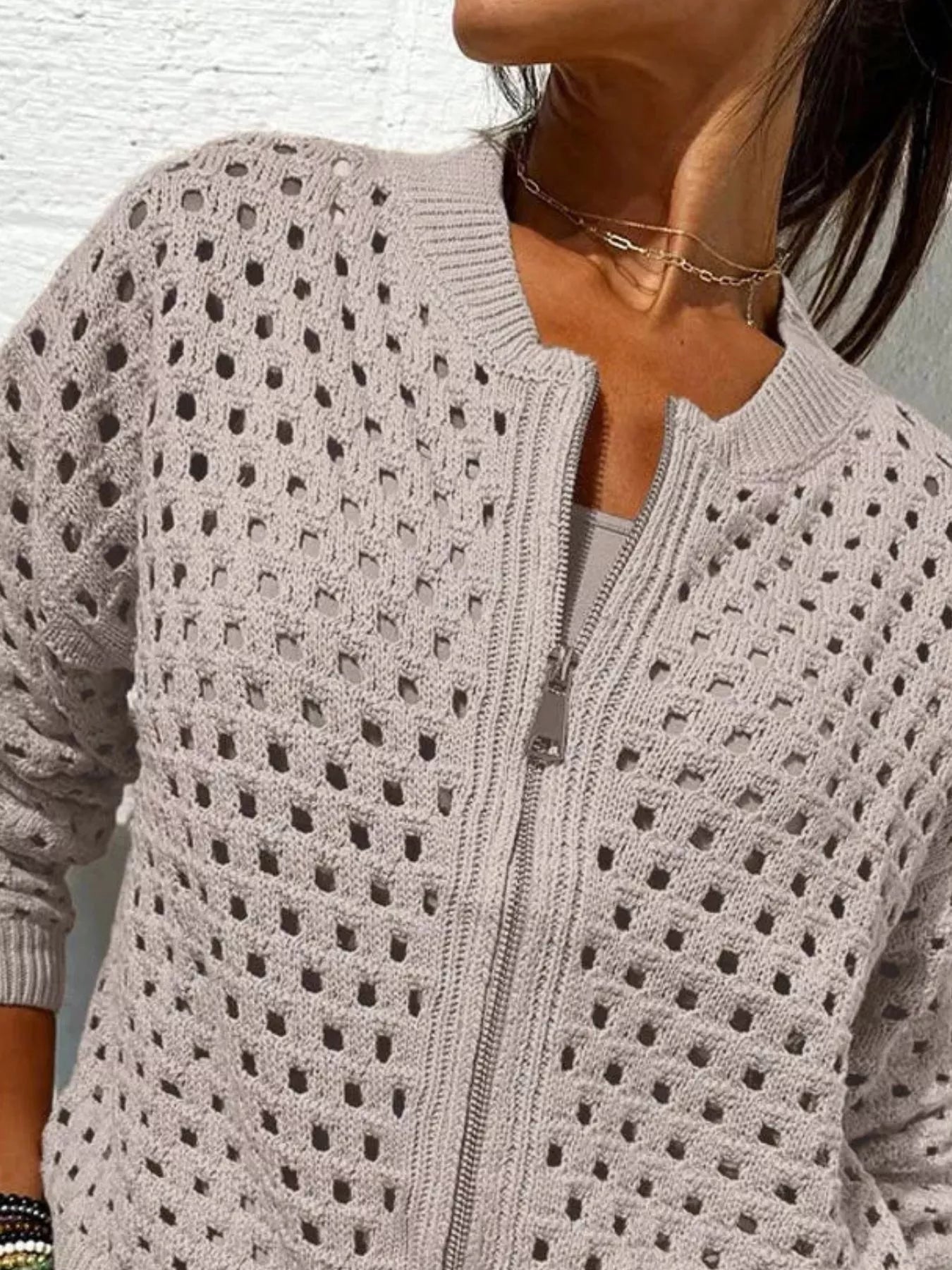 Close up of the light taupe crochet cardigan upper zip and openwork pattern