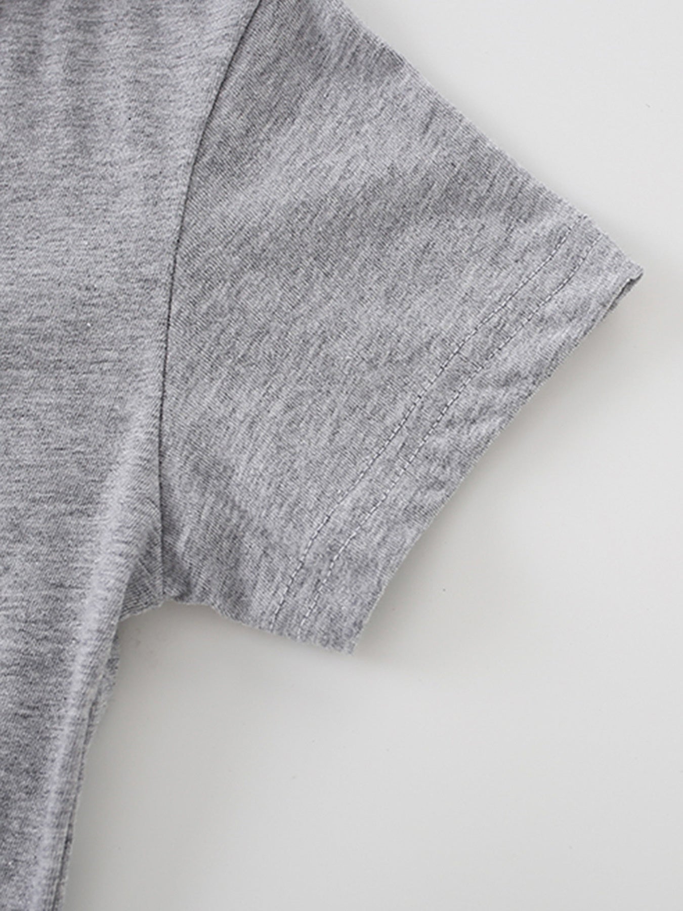 Close-up of the short sleeve hem stitching on a gray children's crew neck T-shirt