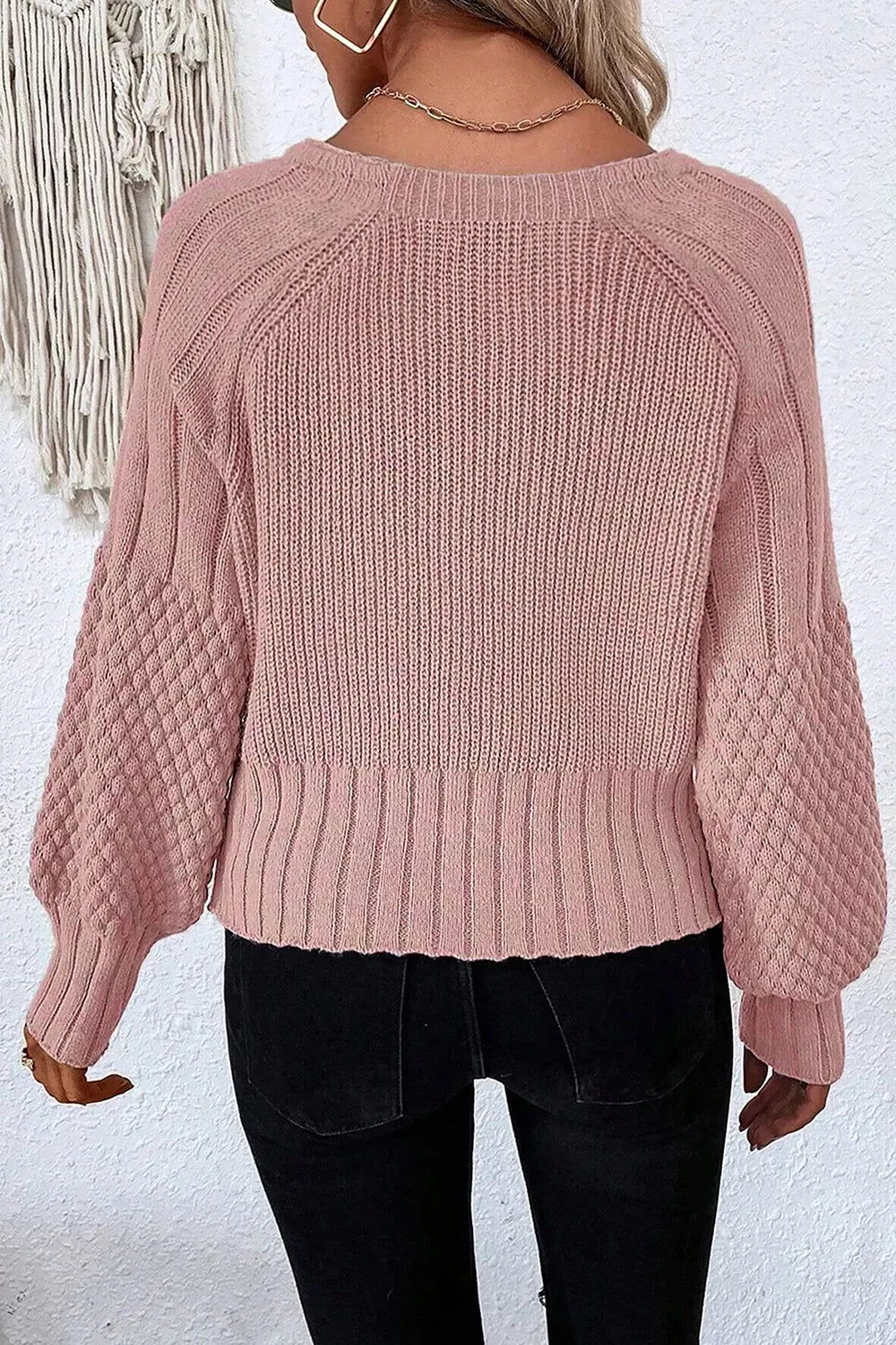On-model back view of a dusty pink V-neck cardigan with ribbed knit and textured sleeves