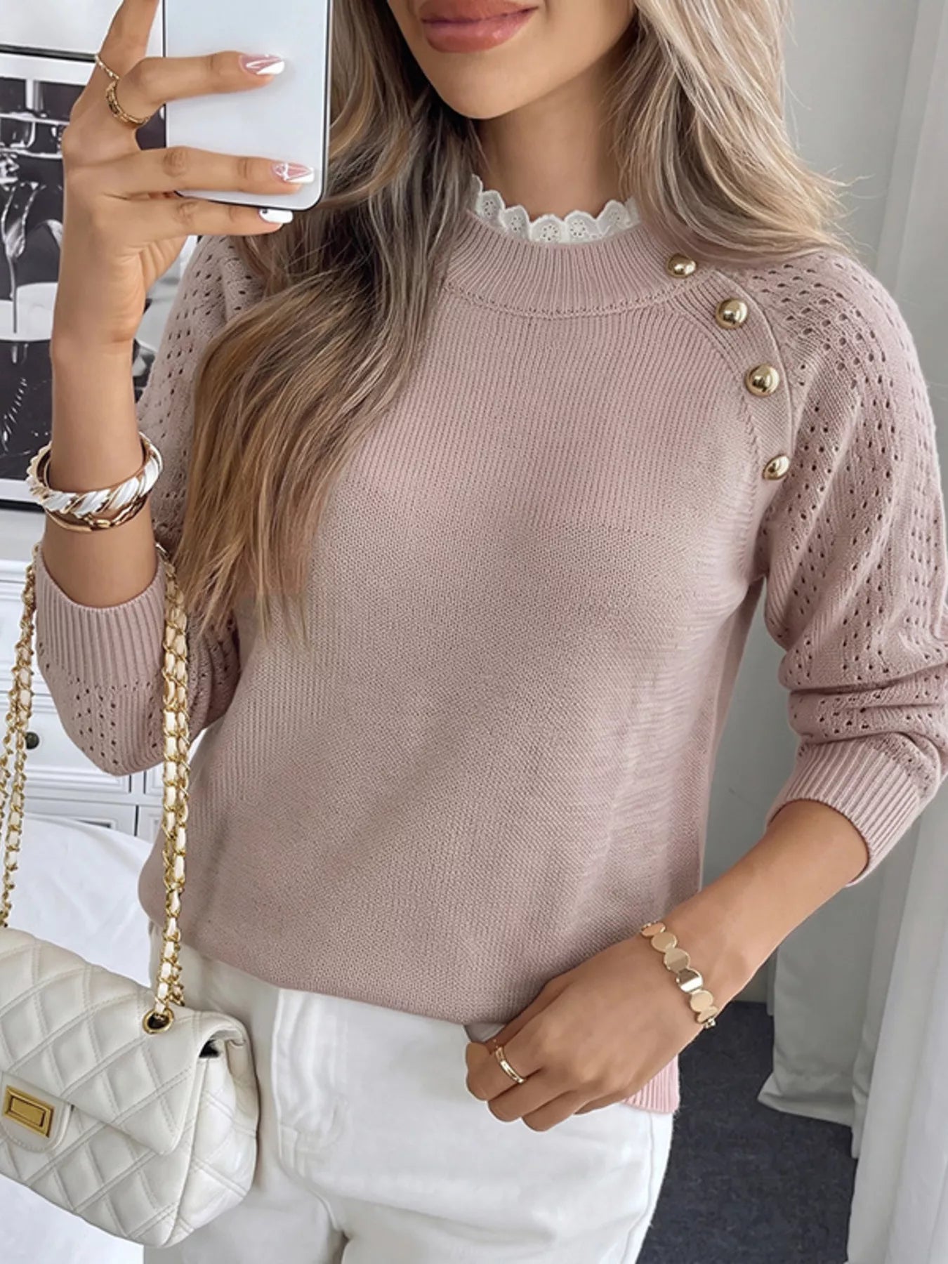 Mirror front view of a pink openwork sweater with gold shoulder buttons and lace collar