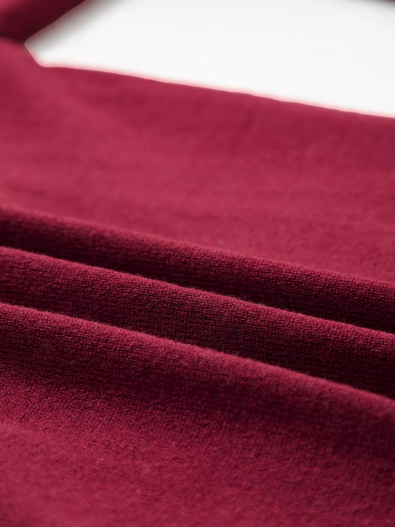 Close view of the folded burgundy knit fabric showing soft texture