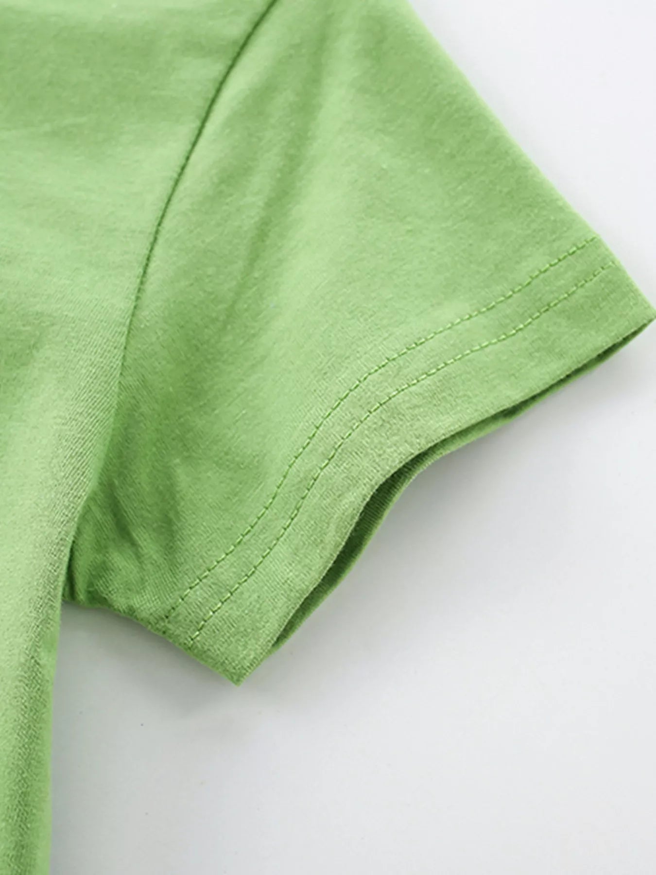 Close-up of lime children's short sleeve hem showing double stitching and soft fabric