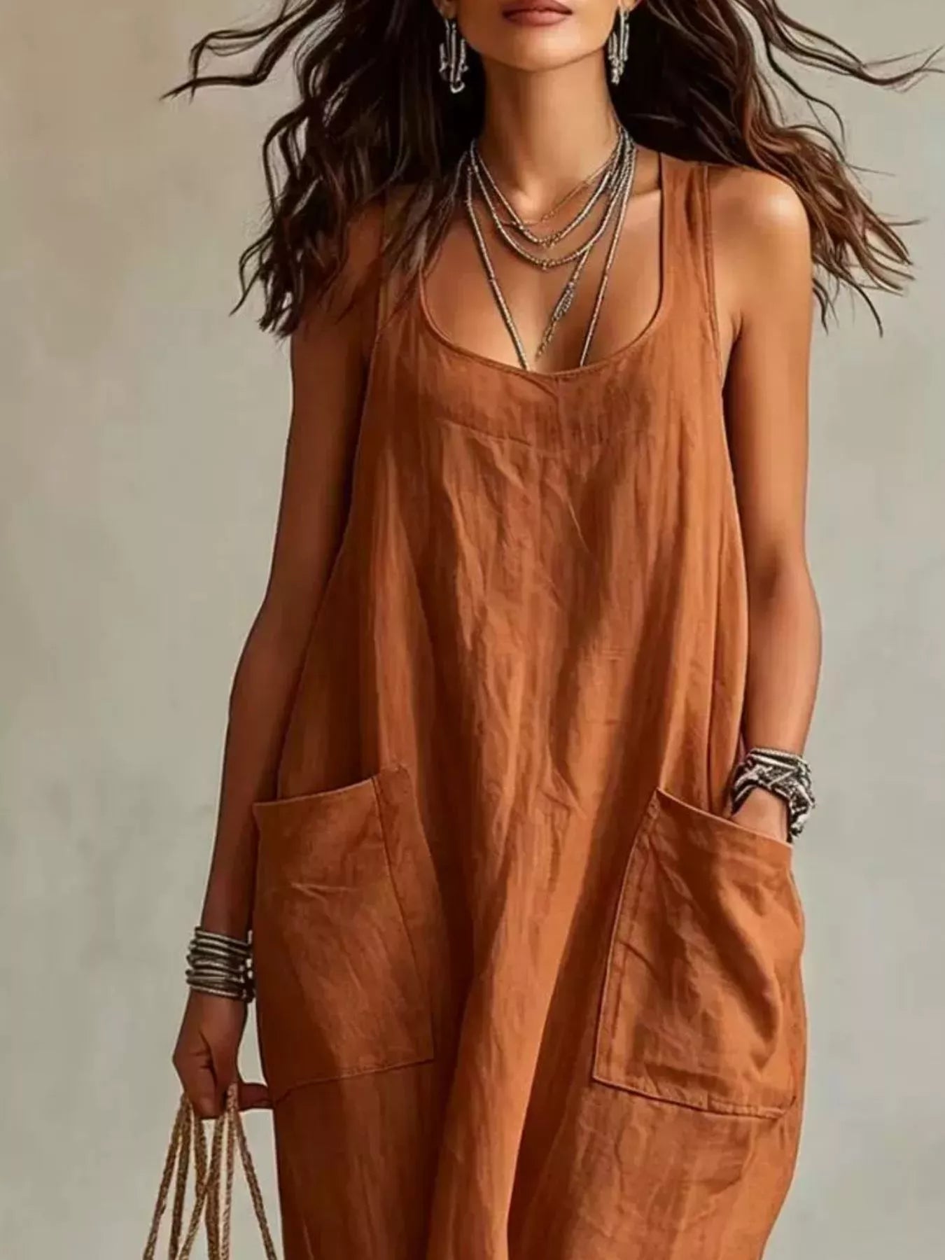 Cropped front view of brown sleeveless scoop neck maxi dress, showing neckline and large pockets