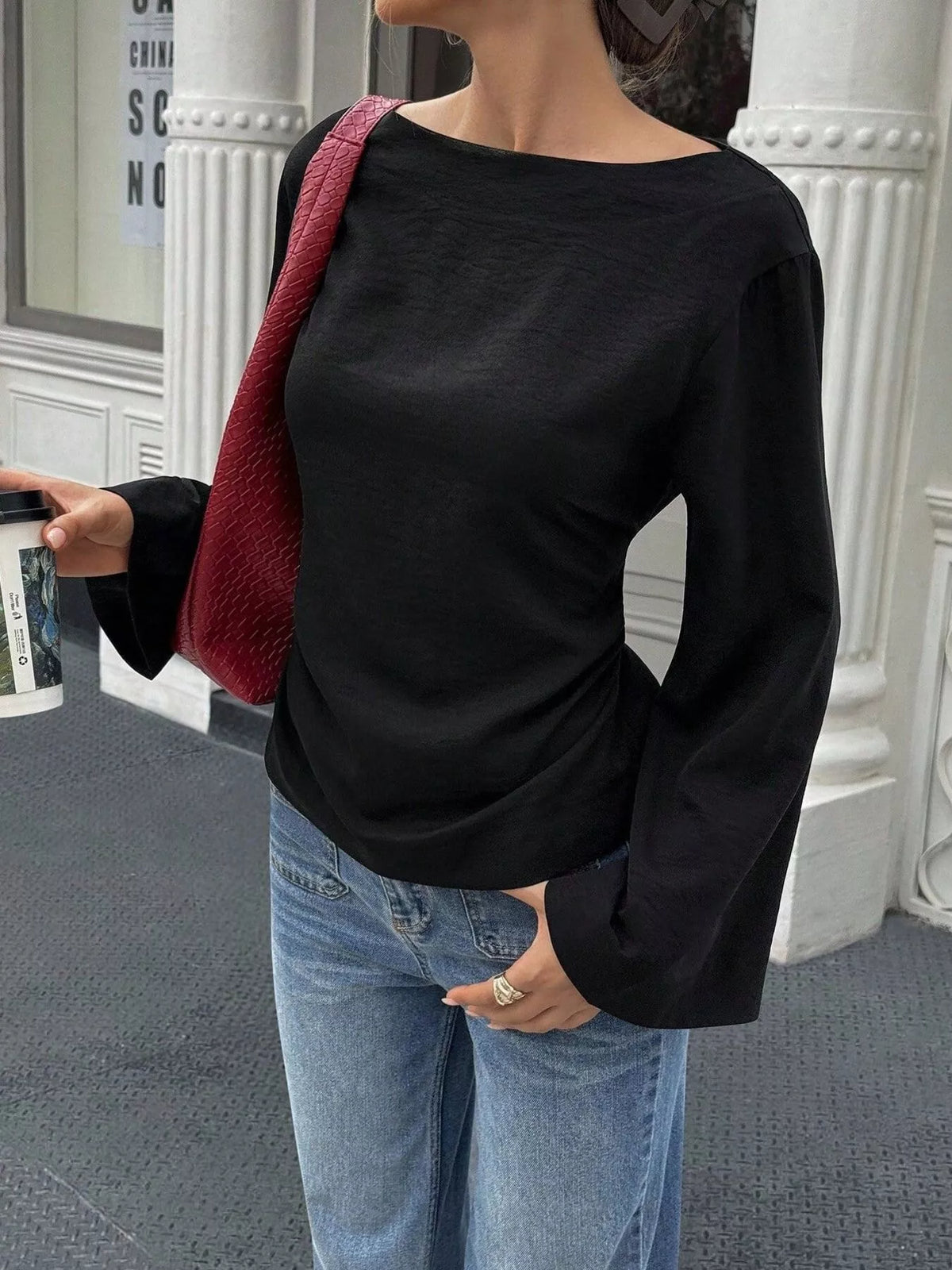 Front view of black boat neck long sleeve slim fit top with flared sleeves on model