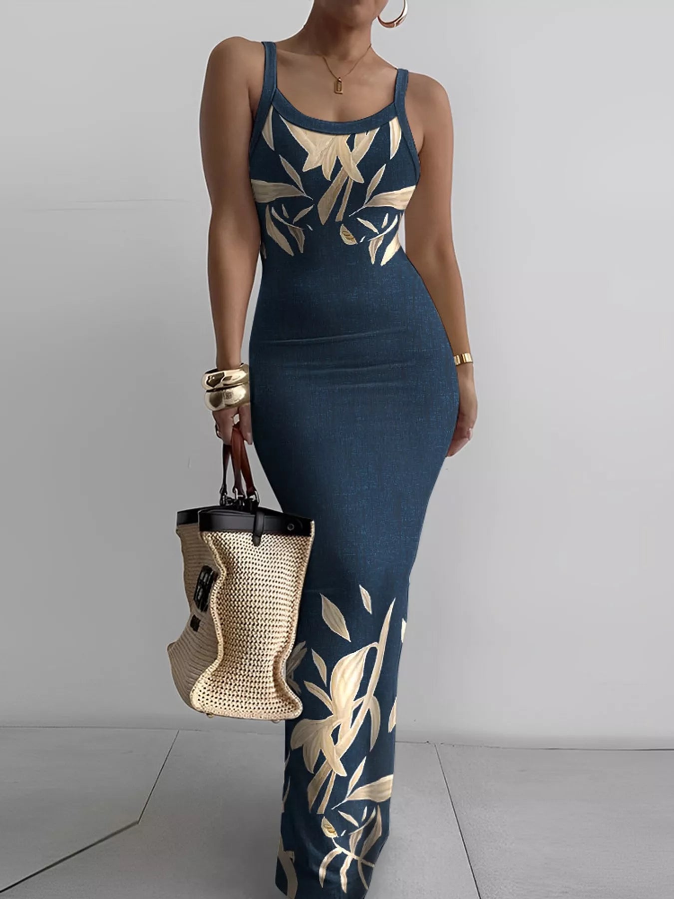 Navy blue sleeveless bodycon maxi dress with cream leaf print worn front facing