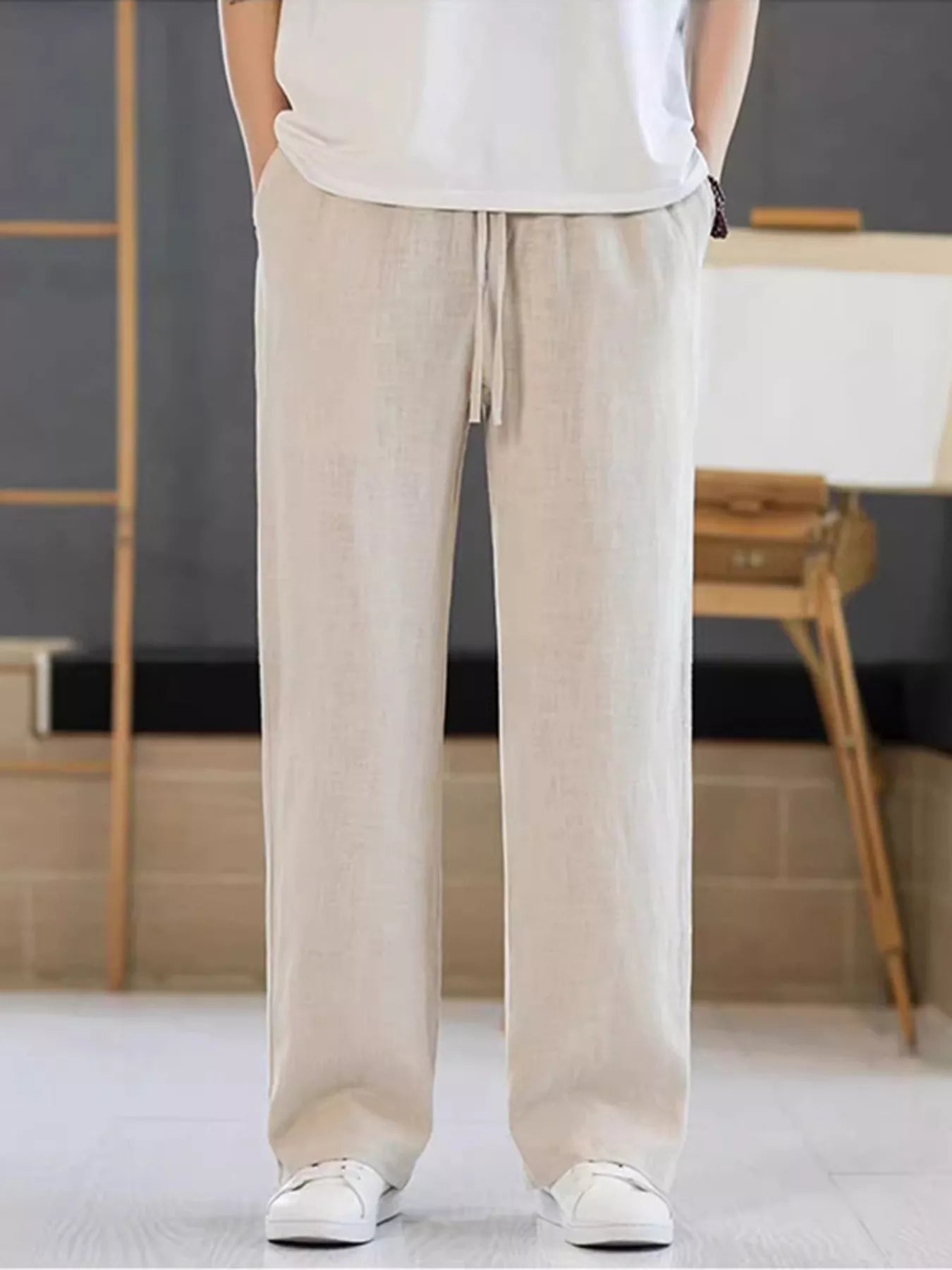 Men's tan casual pants with a drawstring waist and pockets.