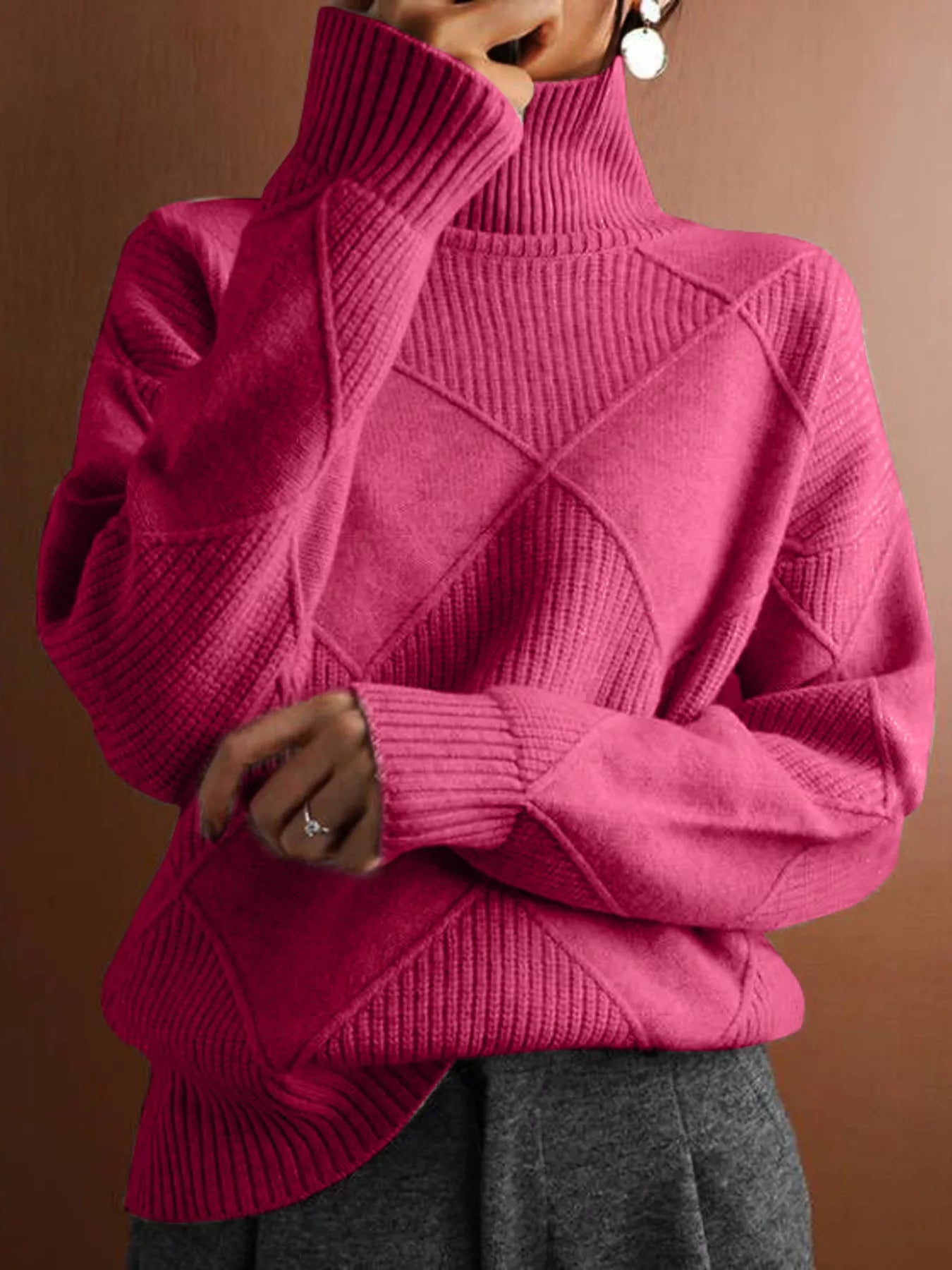 Front torso view of a cerise turtleneck sweater with a tonal diamond pattern