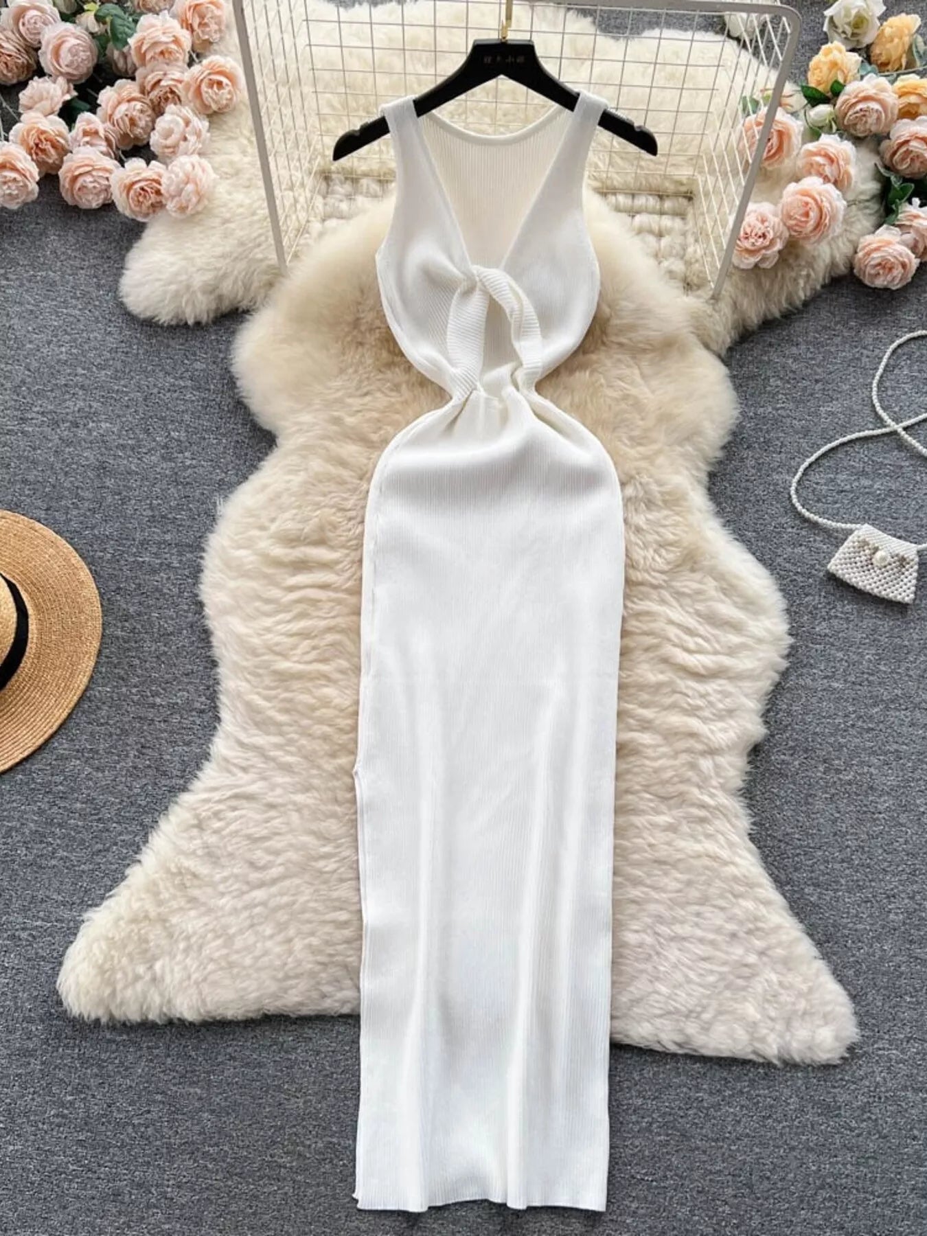 White sleeveless knit bodycon midi dress, back view with knotted open back on hanger