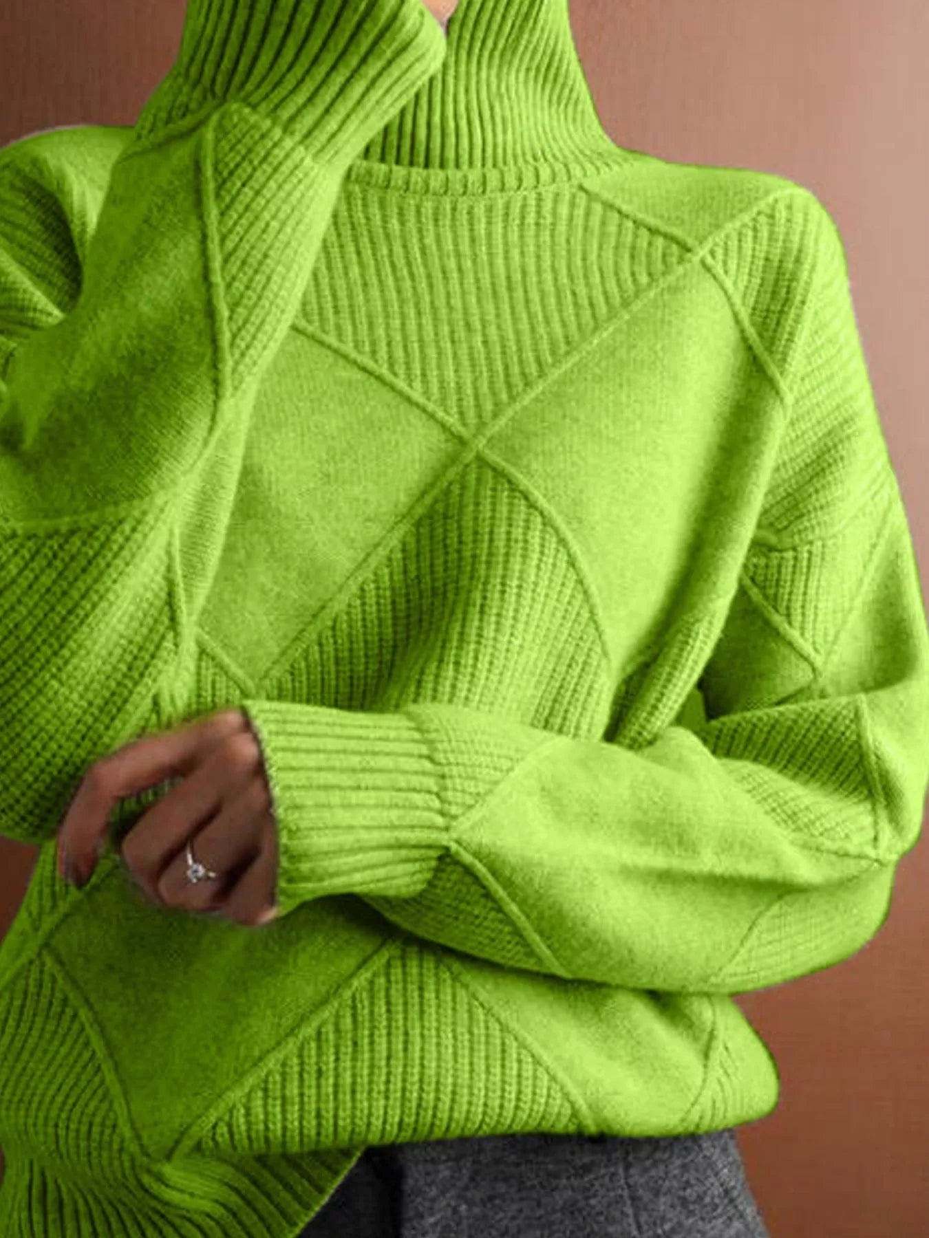 Close torso view of the bright green turtleneck sweater with diamond panels