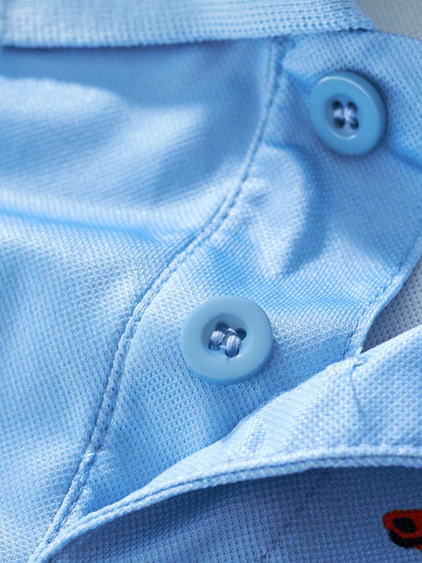 Close-up of the matching sky blue buttons and stitching on the polo placket