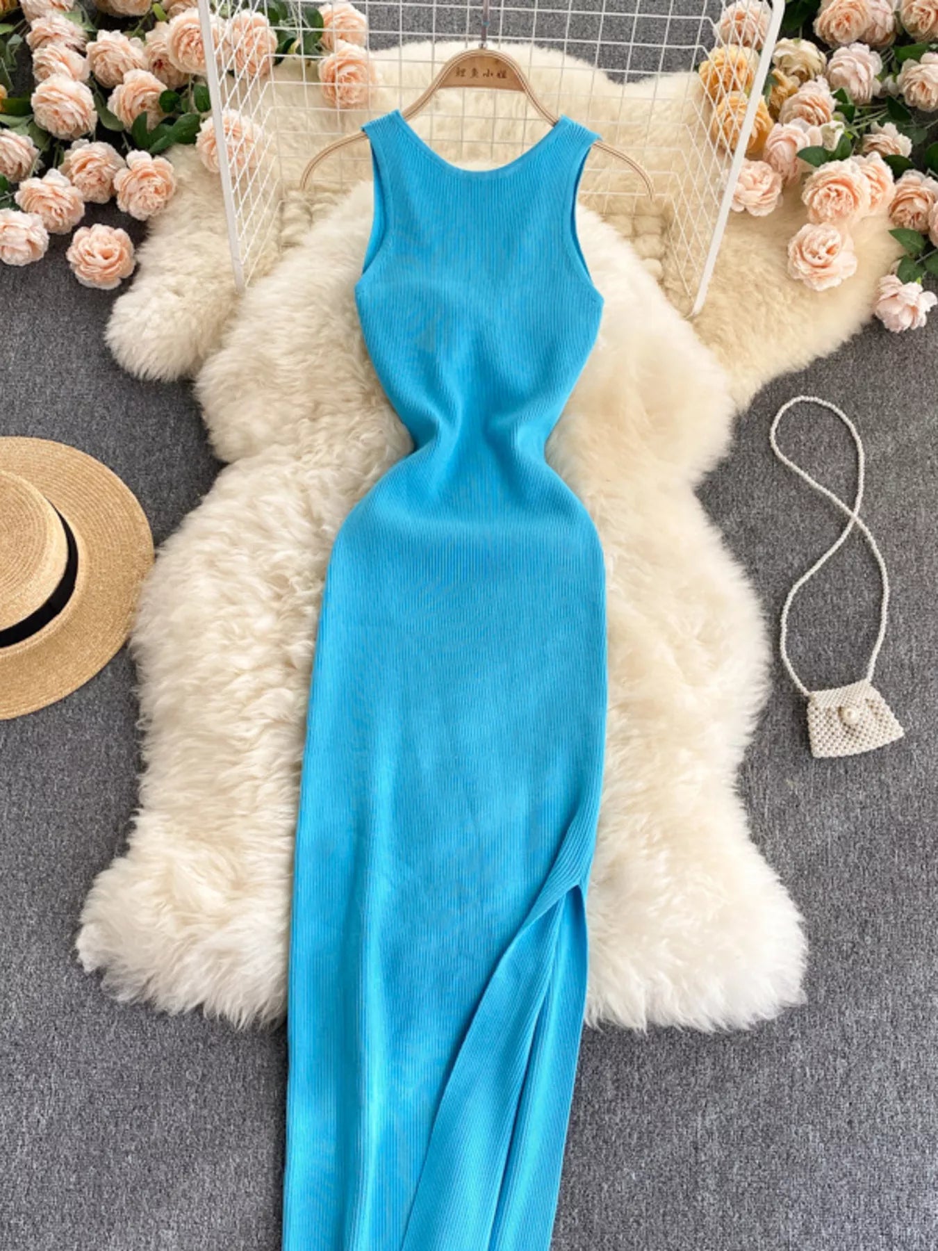 Bright blue sleeveless knit bodycon midi dress, front view with side slit laid flat