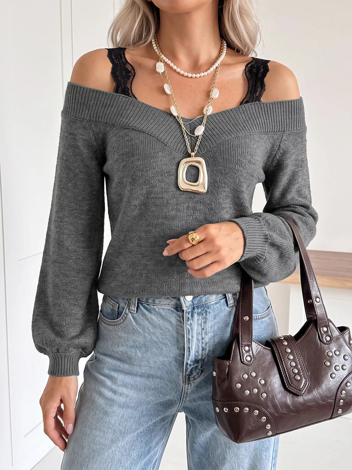 Dark grey off shoulder sweater with black lace trim straps and light jeans