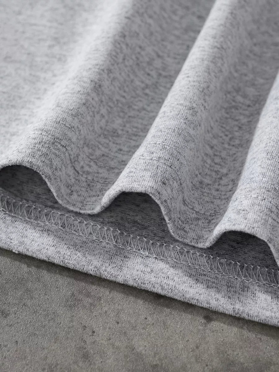 Close up of the light gray bottom hem showing the fabric texture and overlock stitching