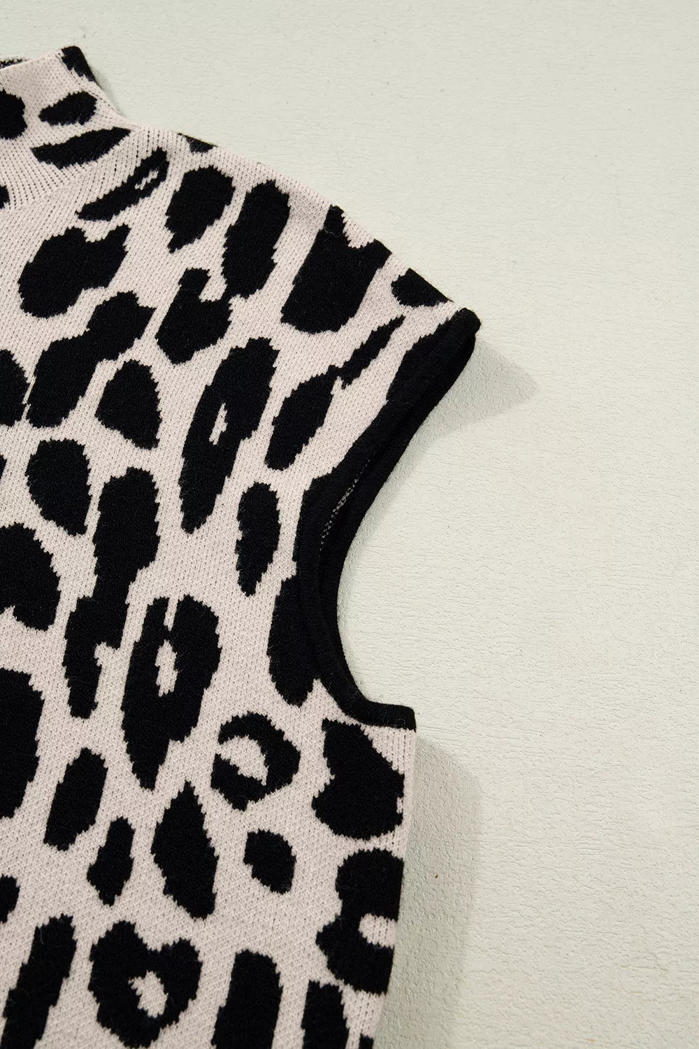 Close up detail of the cap sleeve and armhole on the black and cream leopard print sweater.