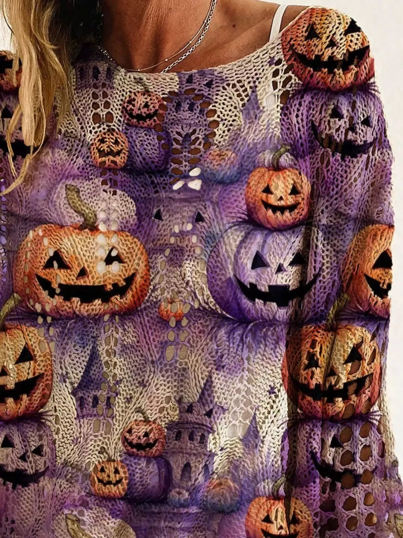 Close up view of the purple openwork knit cover up with orange and purple jack o lanterns.