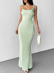 Front view of a light green floral bodycon mermaid maxi dress holding a white handbag