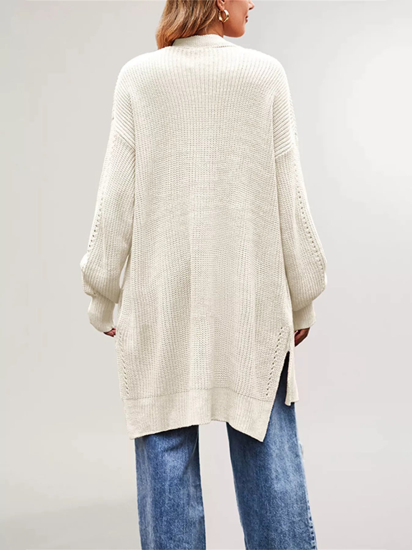 Back view of the cream long open front cardigan with side slits