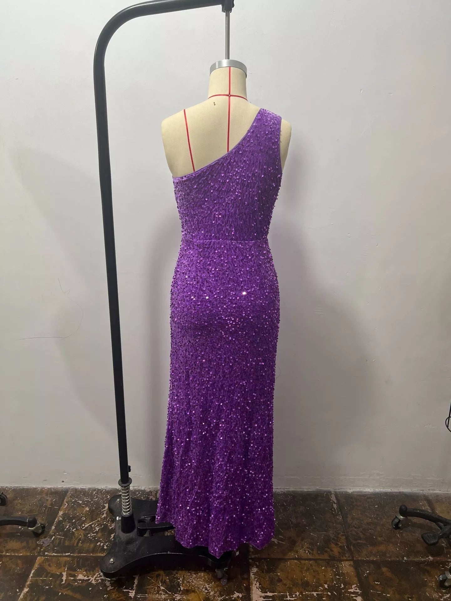 Purple sequin one shoulder evening dress shown from the back on a dress form