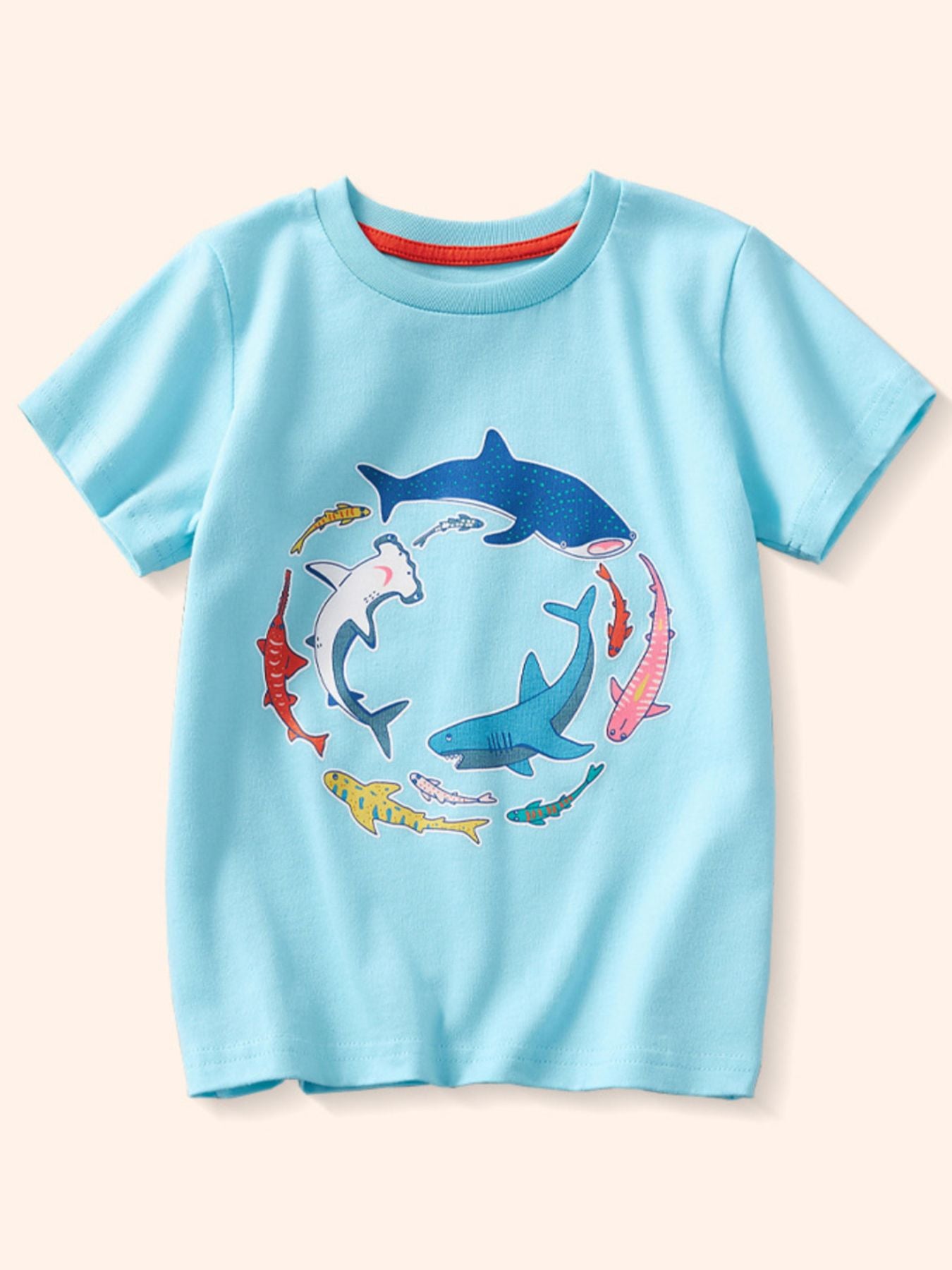 Flat lay front view of a children's pastel blue t-shirt with colorful sharks arranged in a circle
