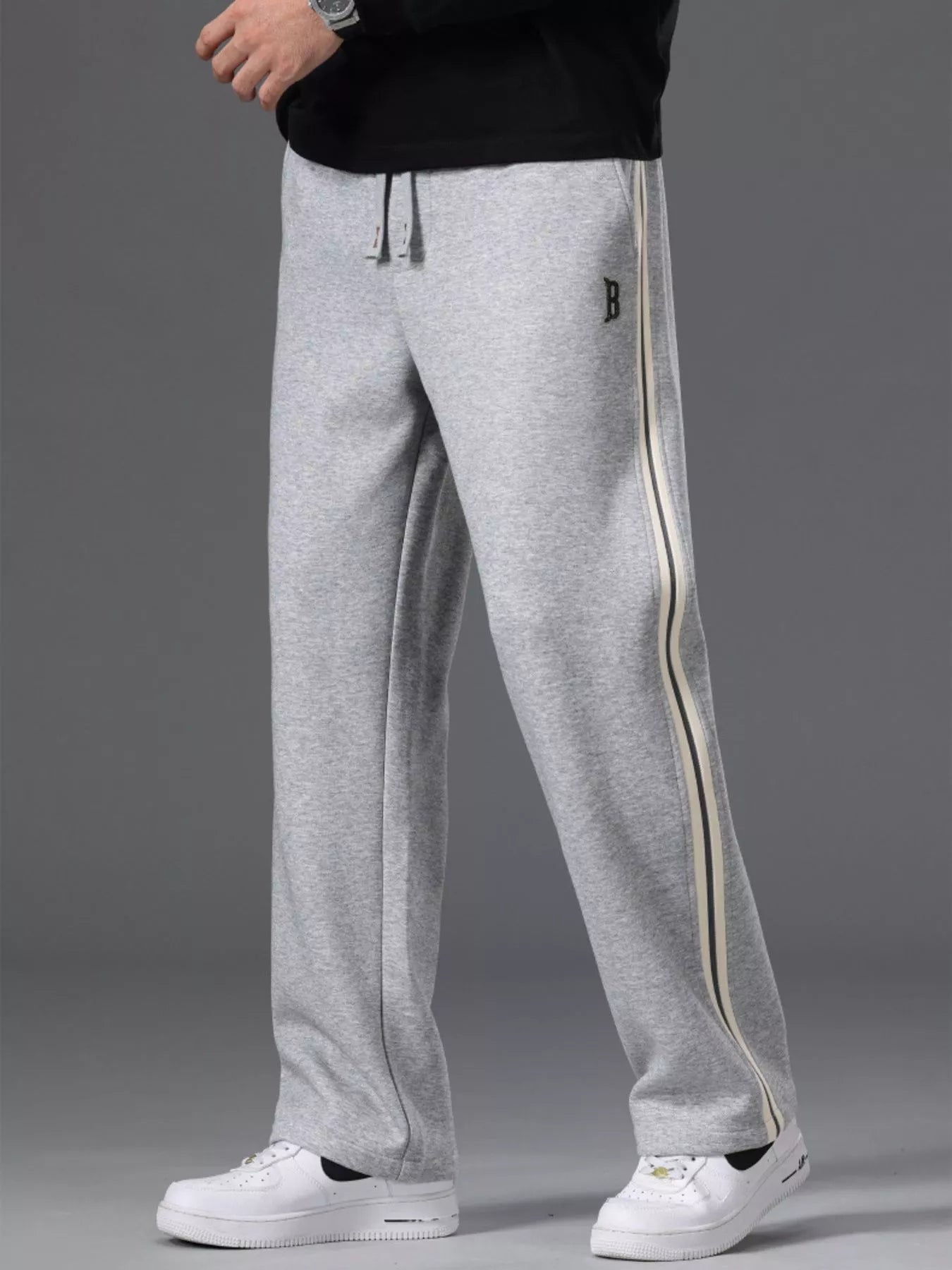 Men's side striped casual pants with a drawstring waist and pockets.