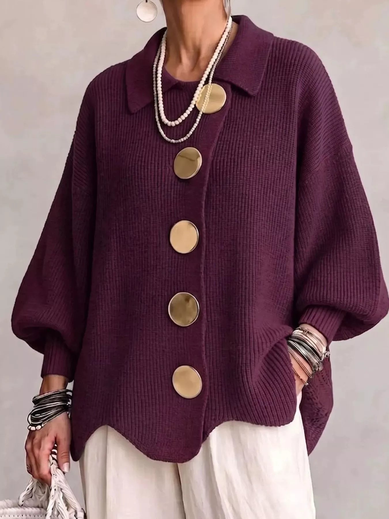 Front view of a burgundy knit cardigan with large gold buttons and lantern sleeves