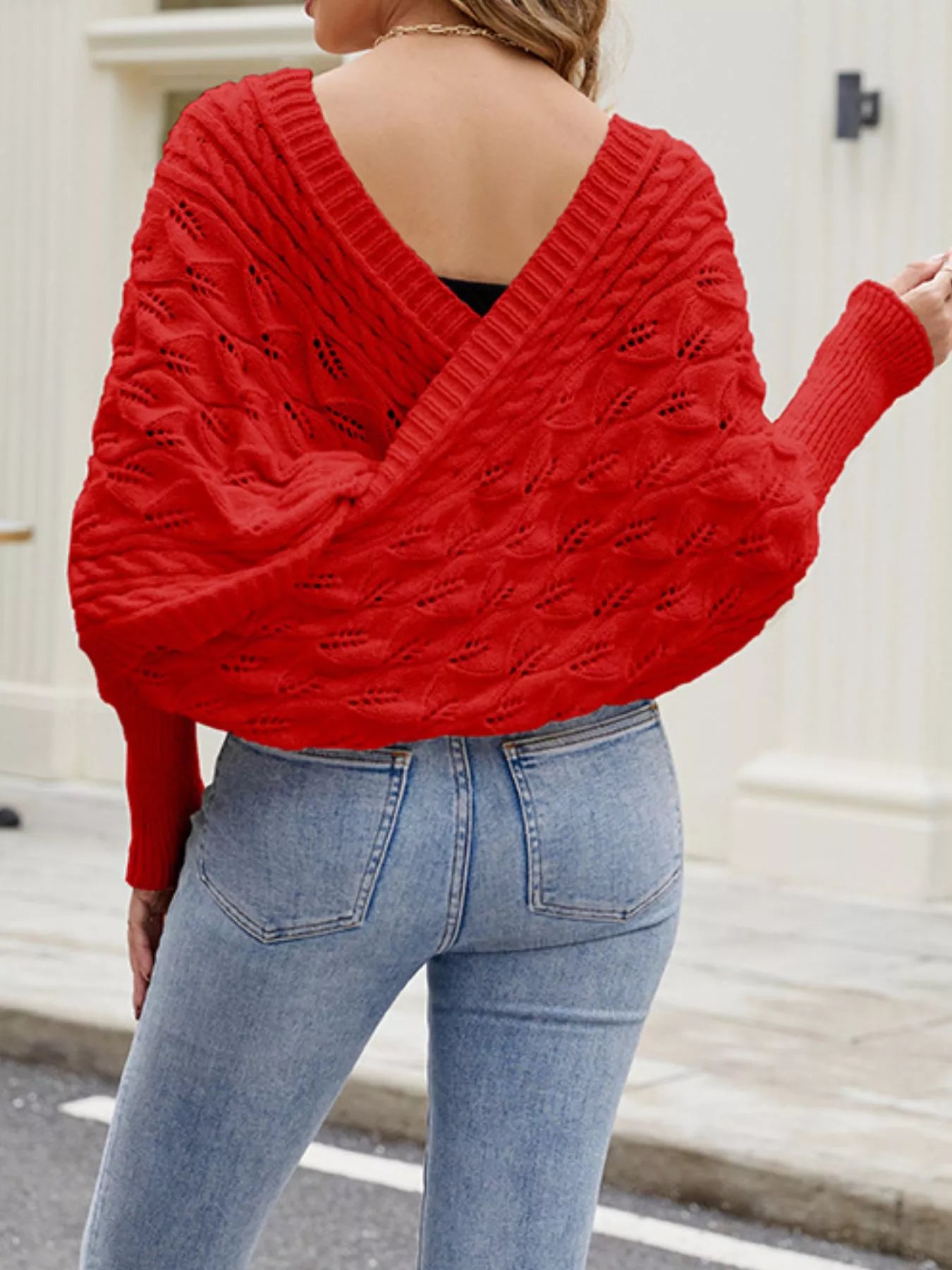 Back view of red batwing sweater with deep V back and cable knit.