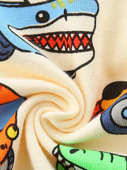 Close-up of the swirled cream fabric and blue shark car print on the children's tee