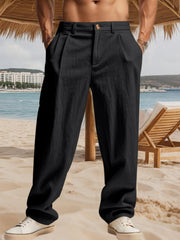 Men's black pleated pants with pockets and a relaxed fit.