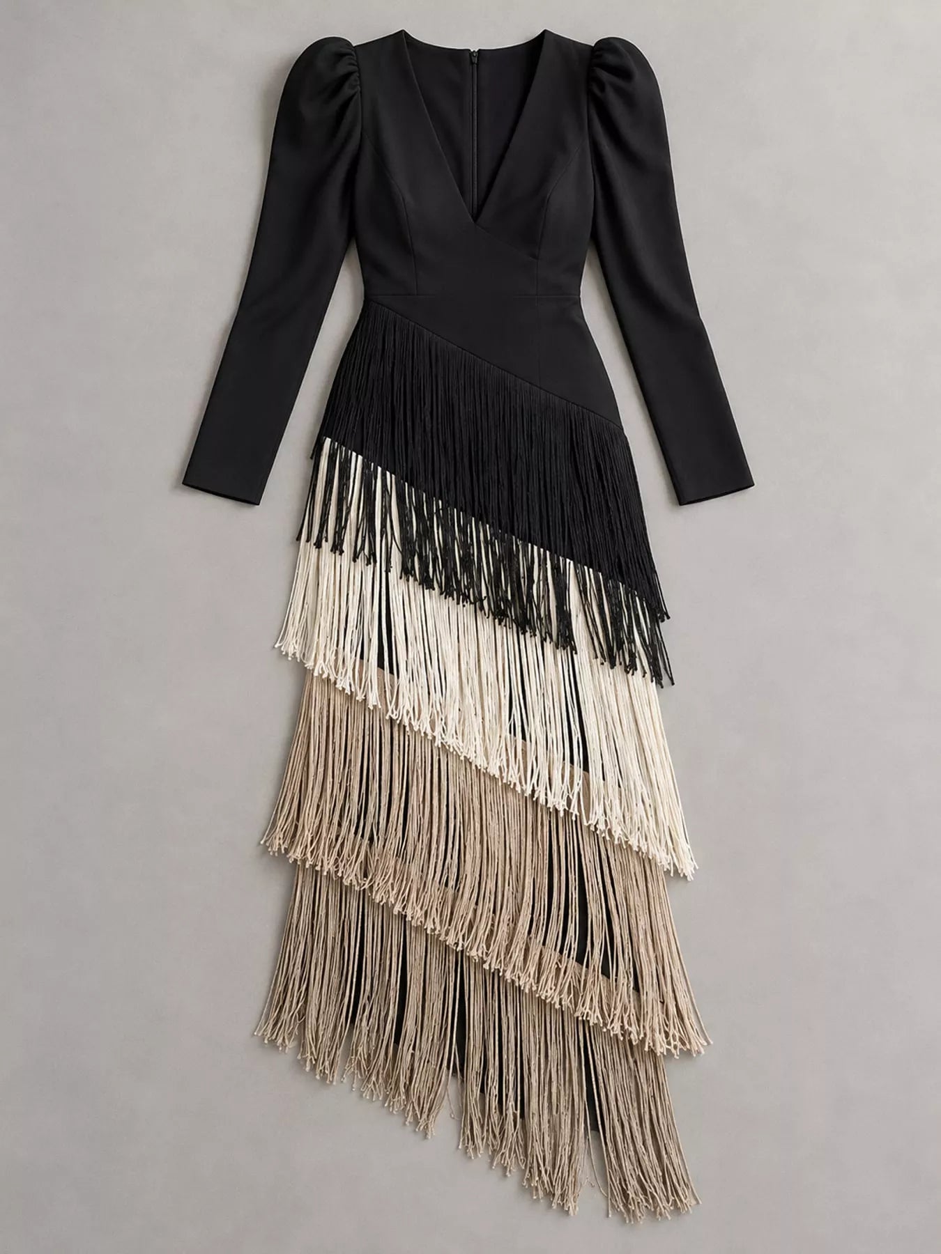 Flat lay view of a black fringed maxi dress with cream and taupe fringe tiers