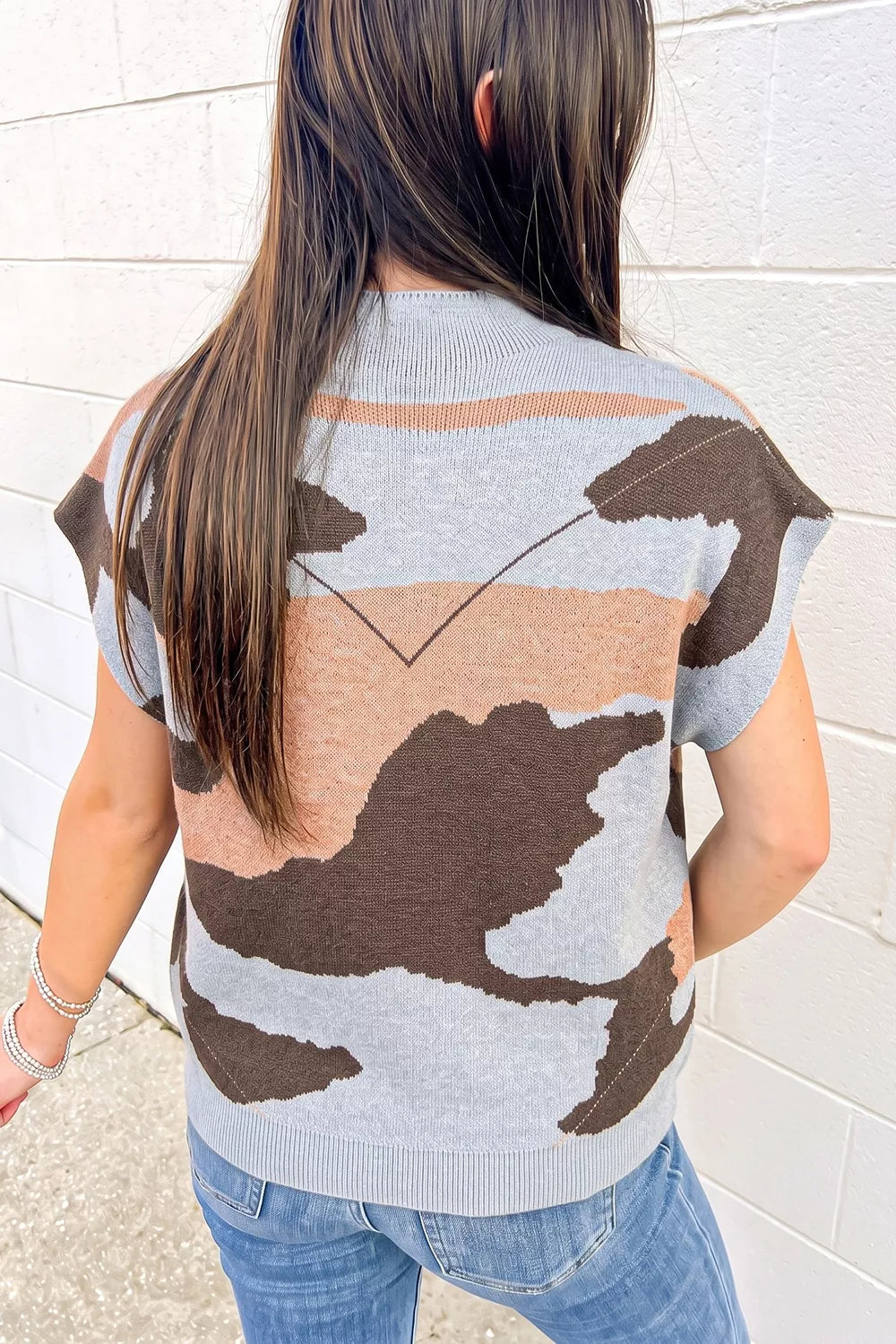 Back view of a gray, brown, and tan camouflage knit top with short sleeves.
