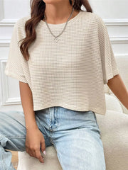 Cream waffle-knit cropped T-shirt with short sleeves, shown worn with light-wash jeans.