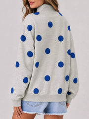 Back view of light gray mock neck oversized sweatshirt with large blue polka dots on model