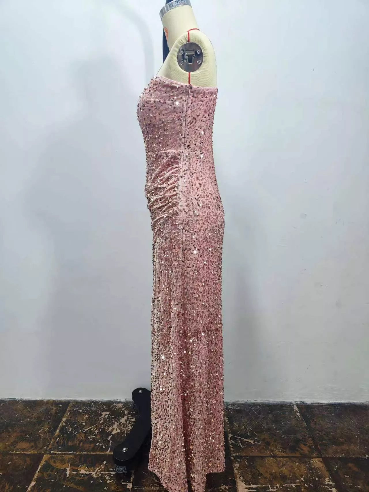 Pink sequin one shoulder evening dress shown in a side view on a dress form