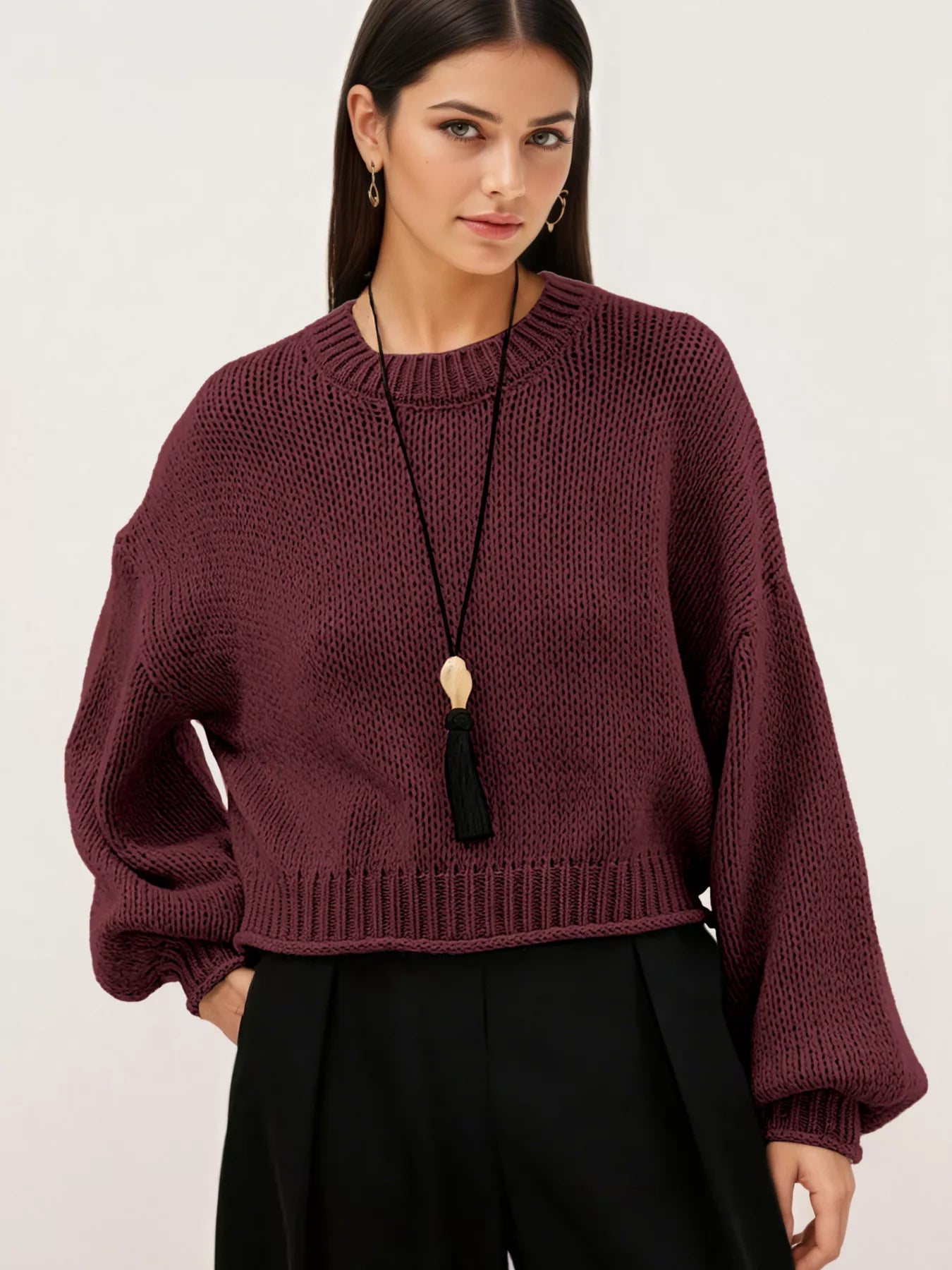On-model front view of a burgundy oversized chunky knit sweater with balloon sleeves