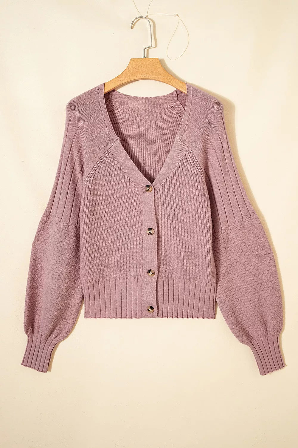 Flat lay front view of a dusty pink V-neck button-down cardigan on a hanger