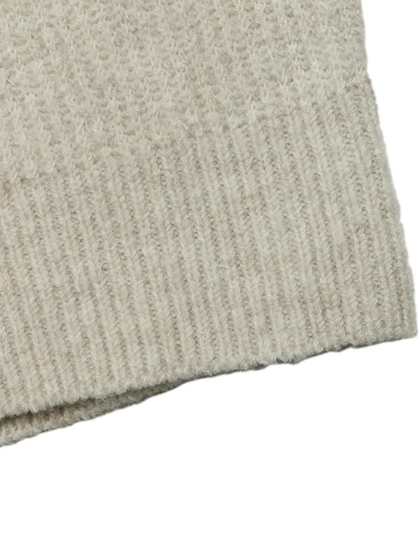 Close up of a cream ribbed knit hem with soft fuzzy texture