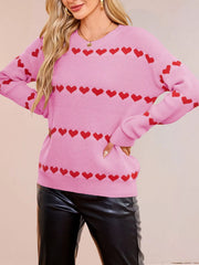 On-model front view of a pink dropped shoulder sweater with rows of red hearts