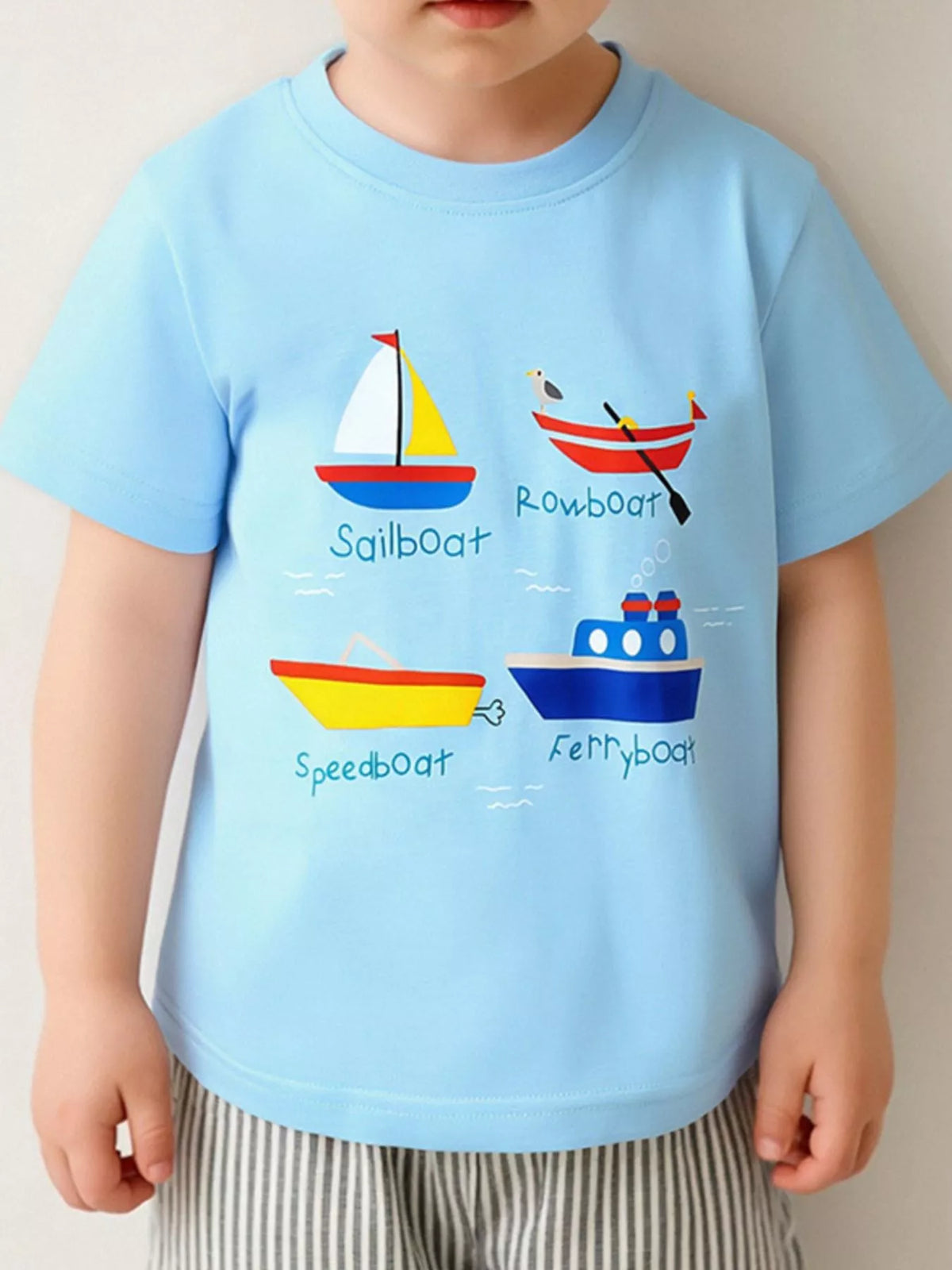 Children's pastel blue T-shirt with a cartoon boat design and short sleeves.