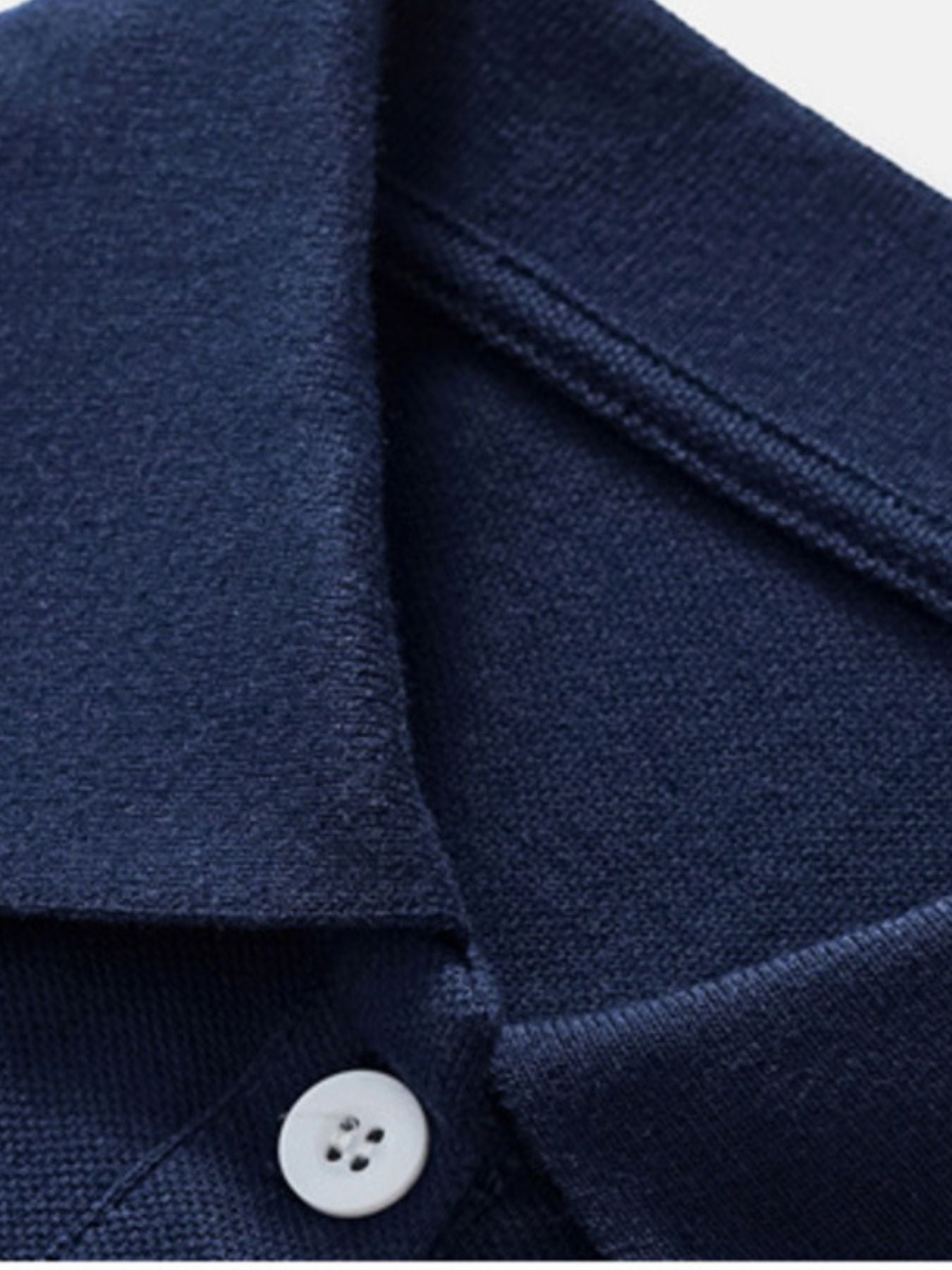 Close-up of the dark navy polo collar and white button placket