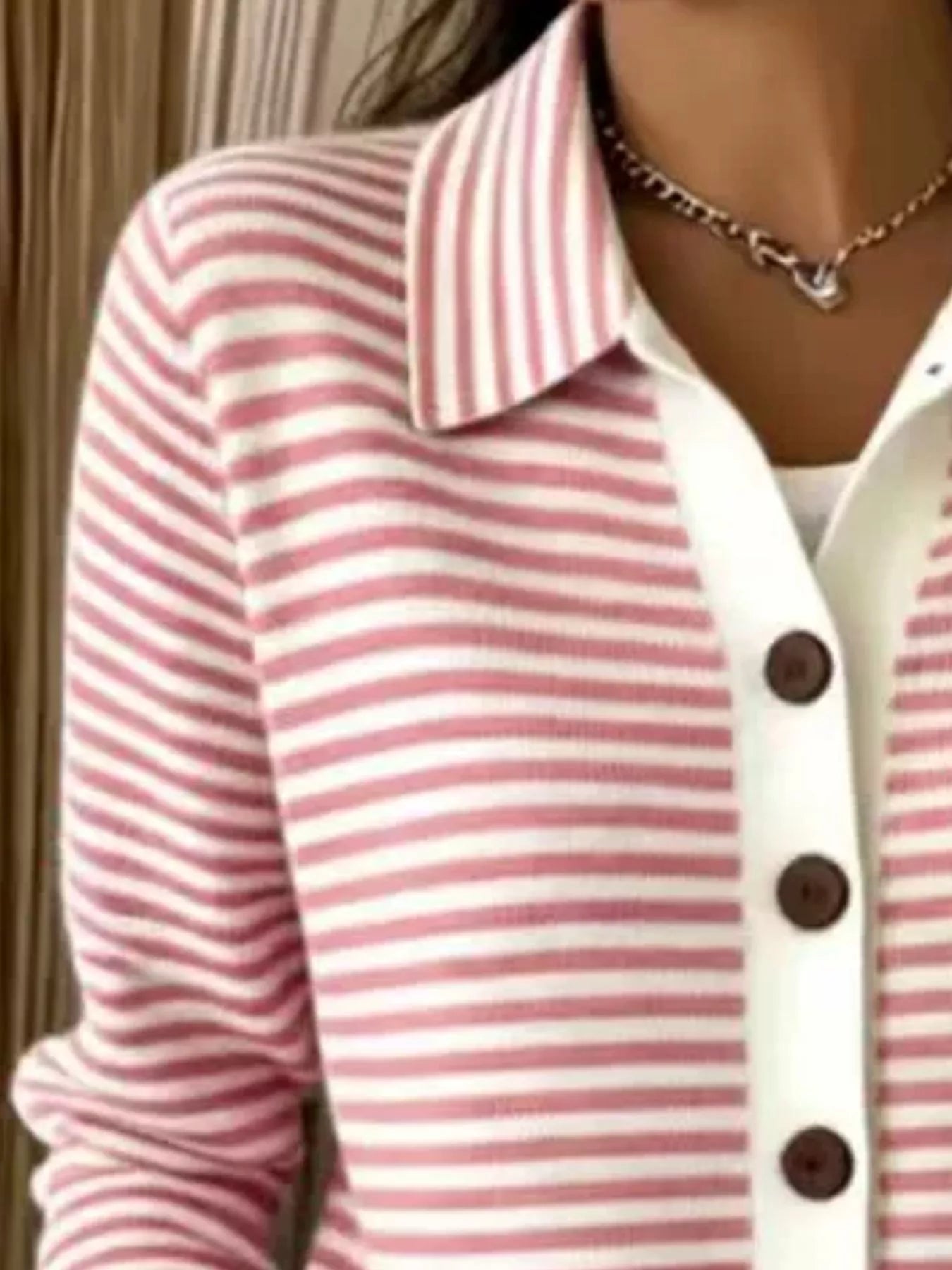 Close-up on-model view of pink and white striped collared cardigan with brown buttons