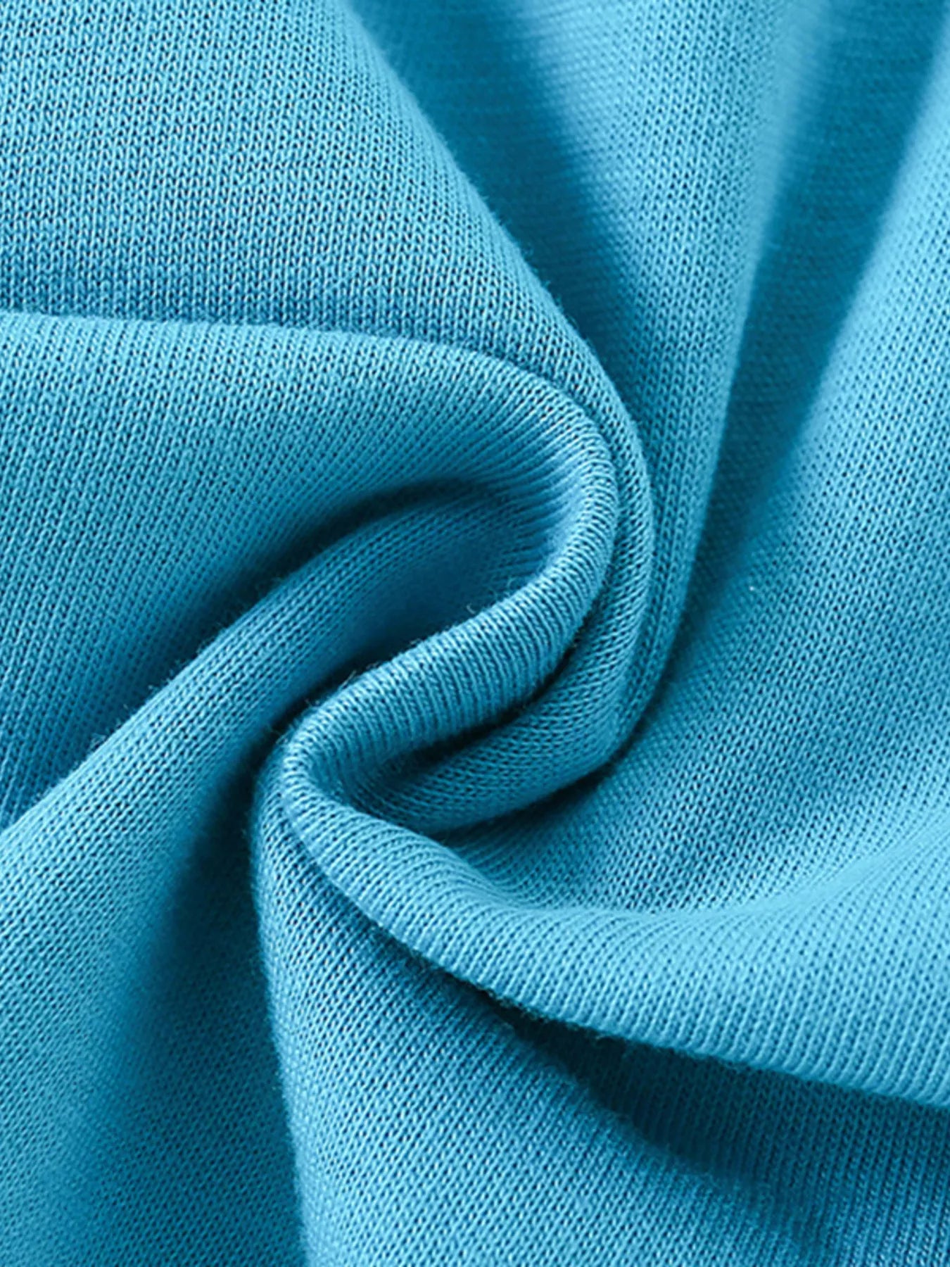 Close-up of soft folded cerulean knit fabric texture of children's short sleeve t-shirt