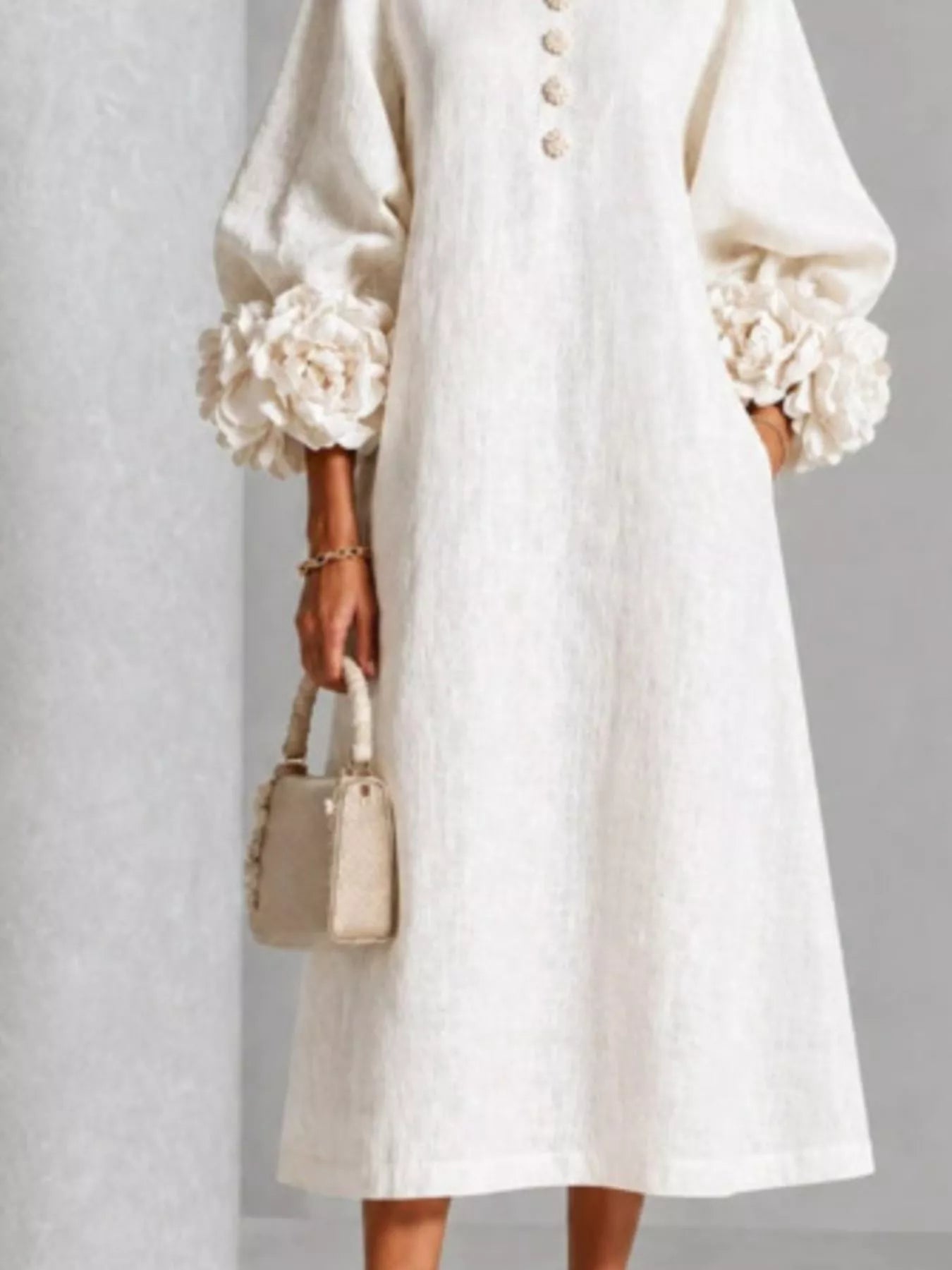 Lower front view of the white round neck midi dress skirt with floral cuffs and loose fit