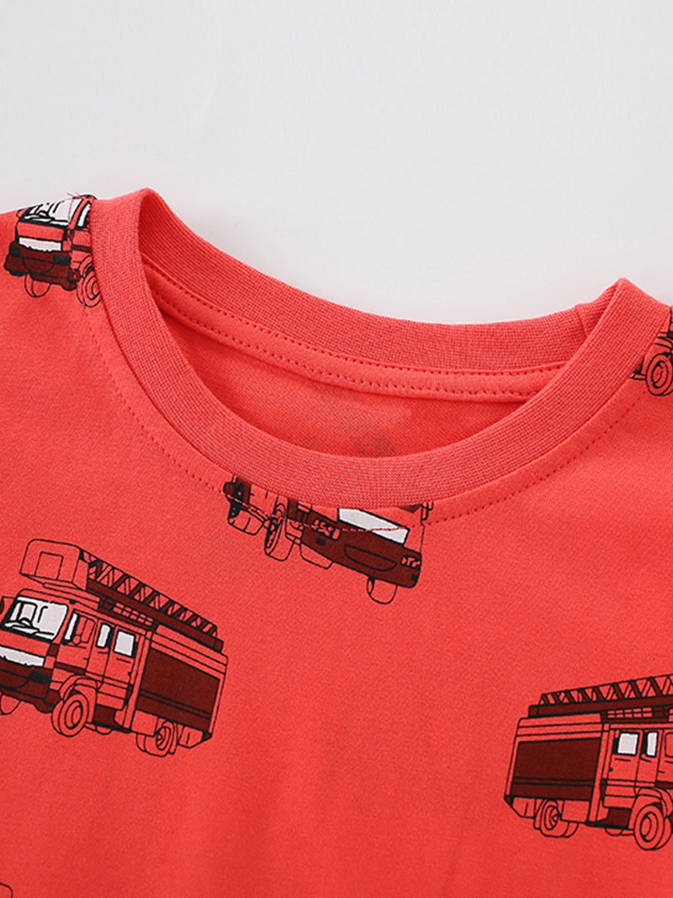 Close-up detail of the red crew neckline and stitching on children's fire truck T-shirt