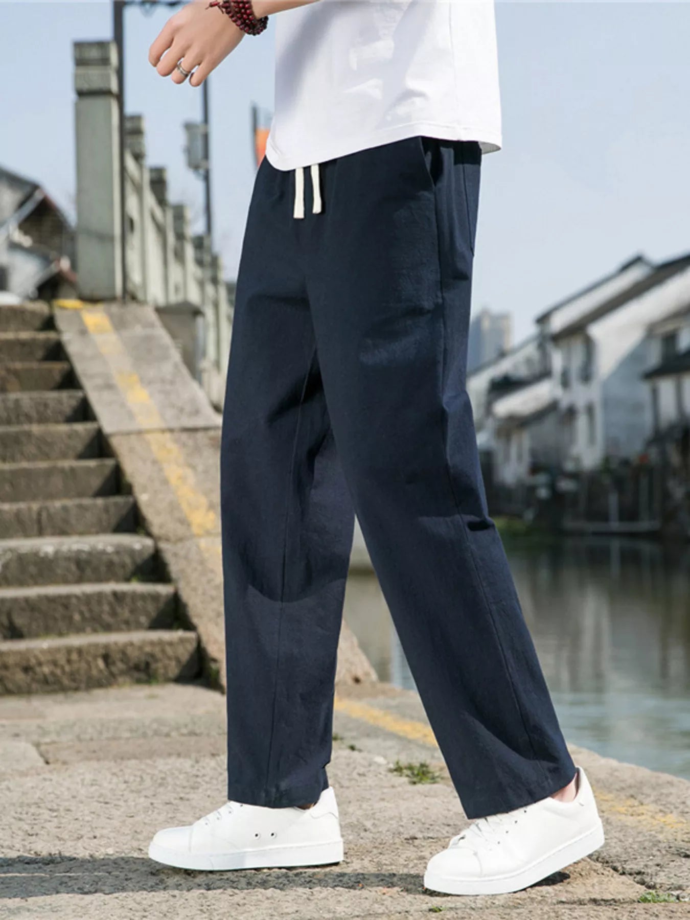 Men's navy blue loose-fit casual pants with a drawstring waist and pockets.