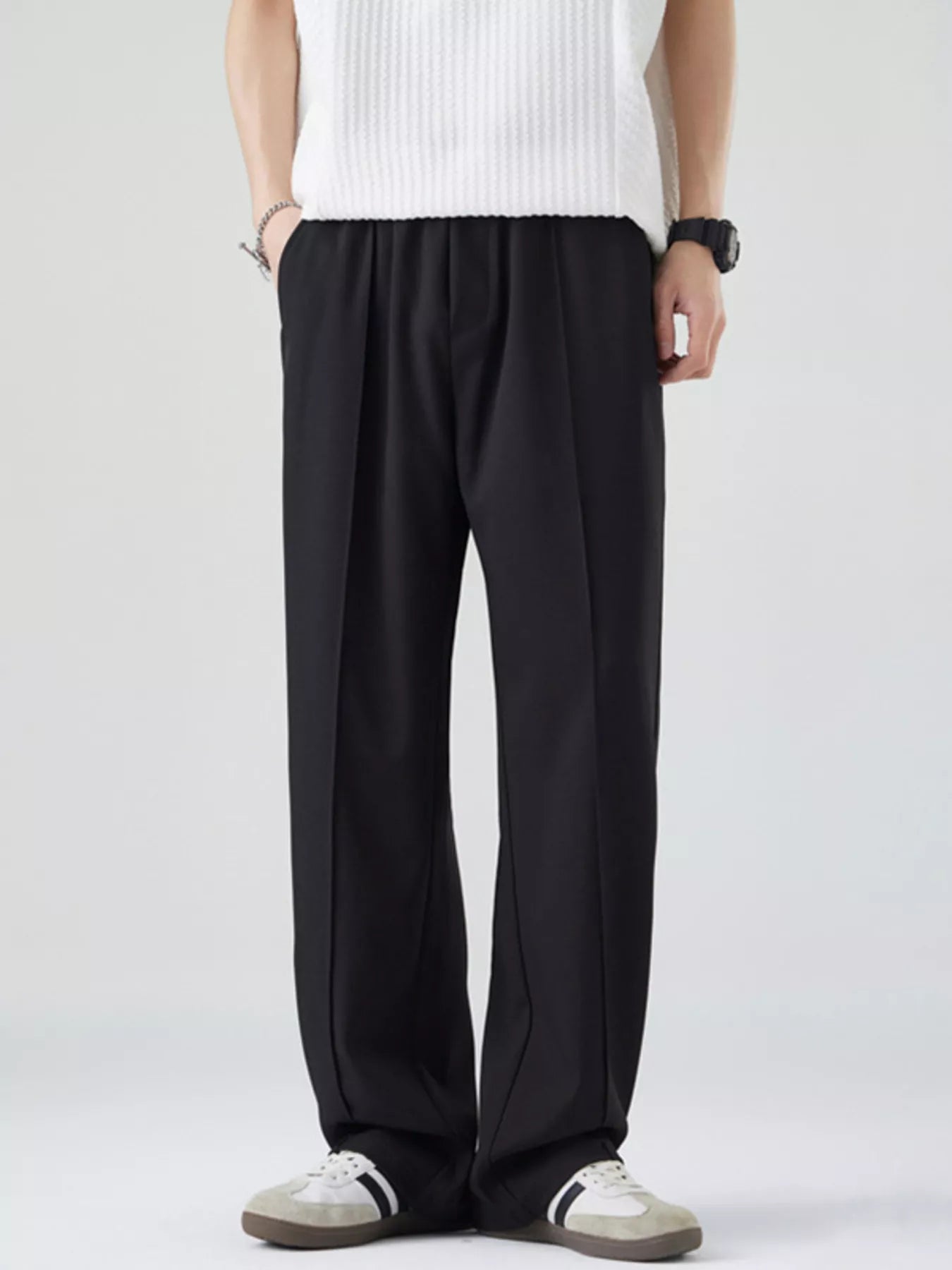 Men's black loose-fit casual pants with a drawstring waist and pockets.