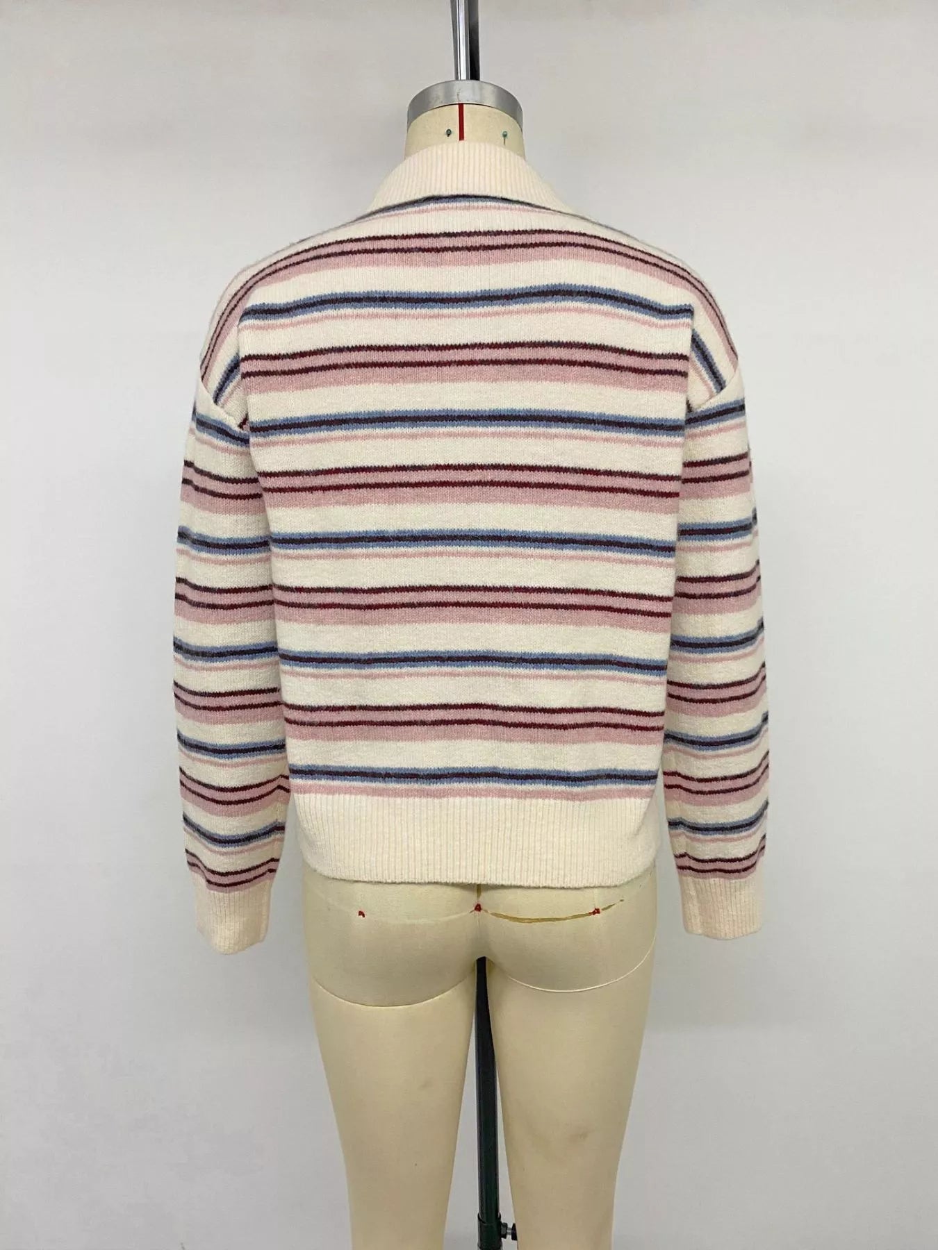 Back view of a cream striped polo sweater with pink and blue stripes on a mannequin
