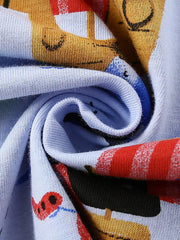 Close-up of the twisted light blue fabric showing the colorful pirate print texture