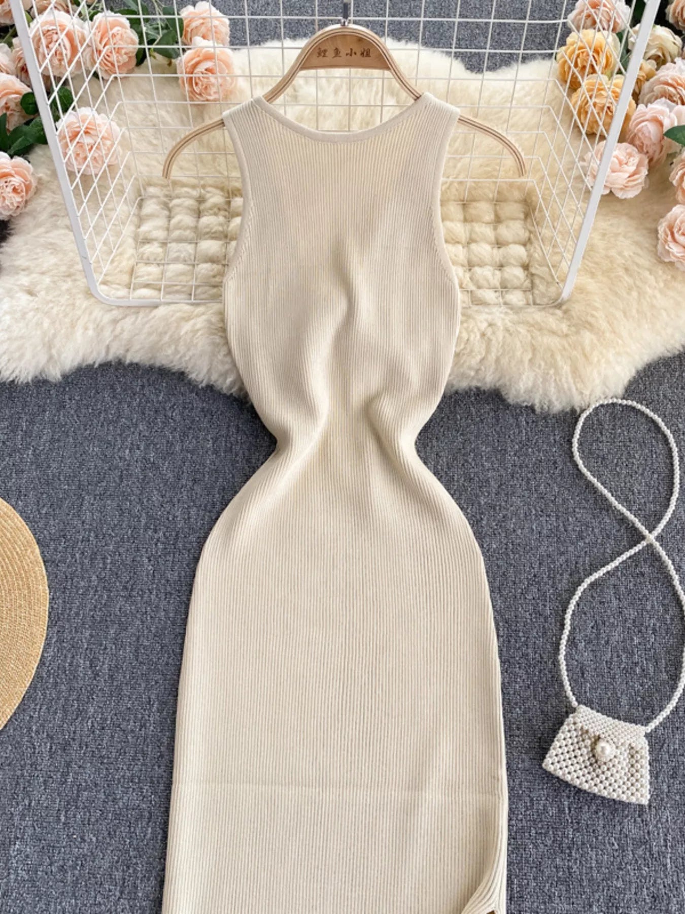 Front bodice of cream white ribbed knit sleeveless bodycon midi dress on hanger